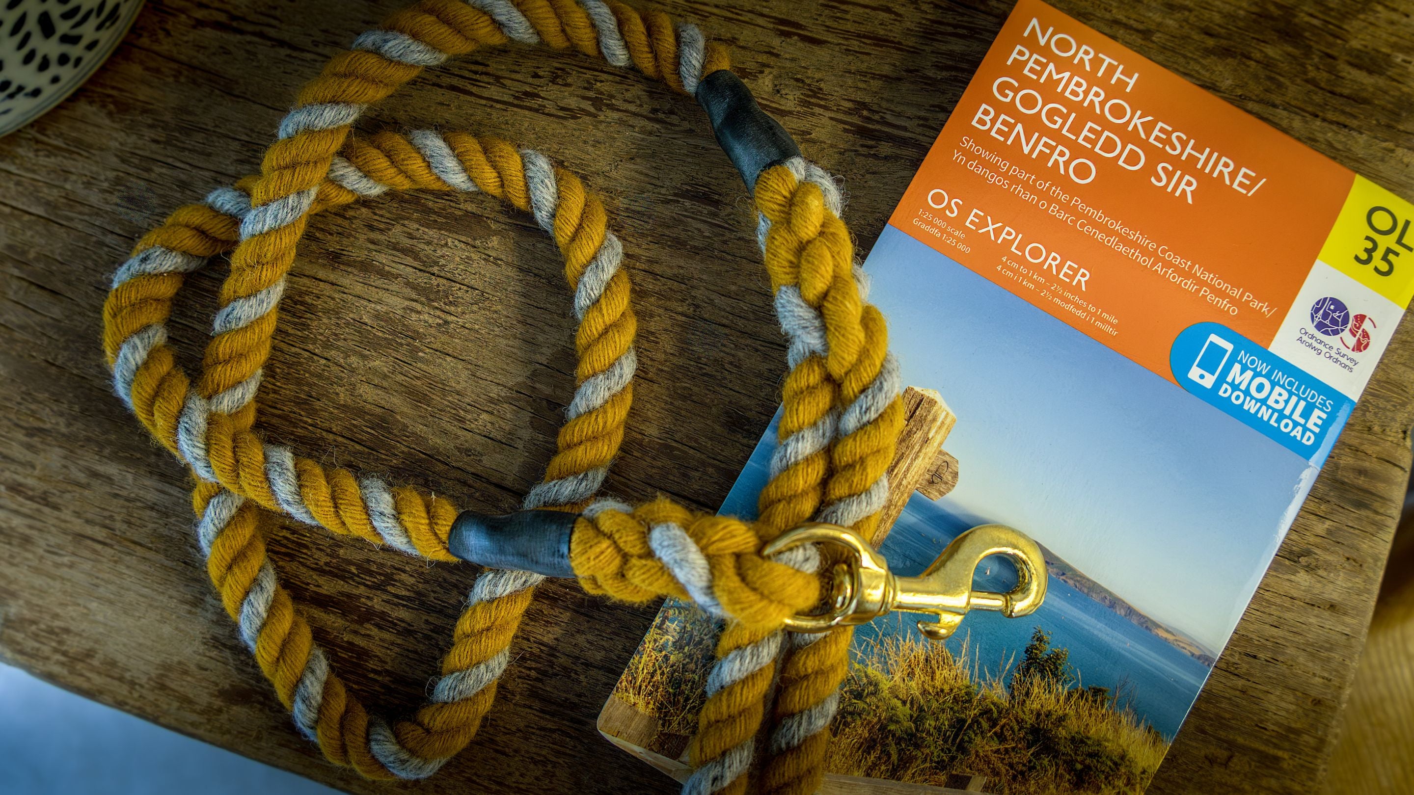 A walking map and guest's dog lead on a wooden table at Newgale Wood Farm, Pembrokeshire
