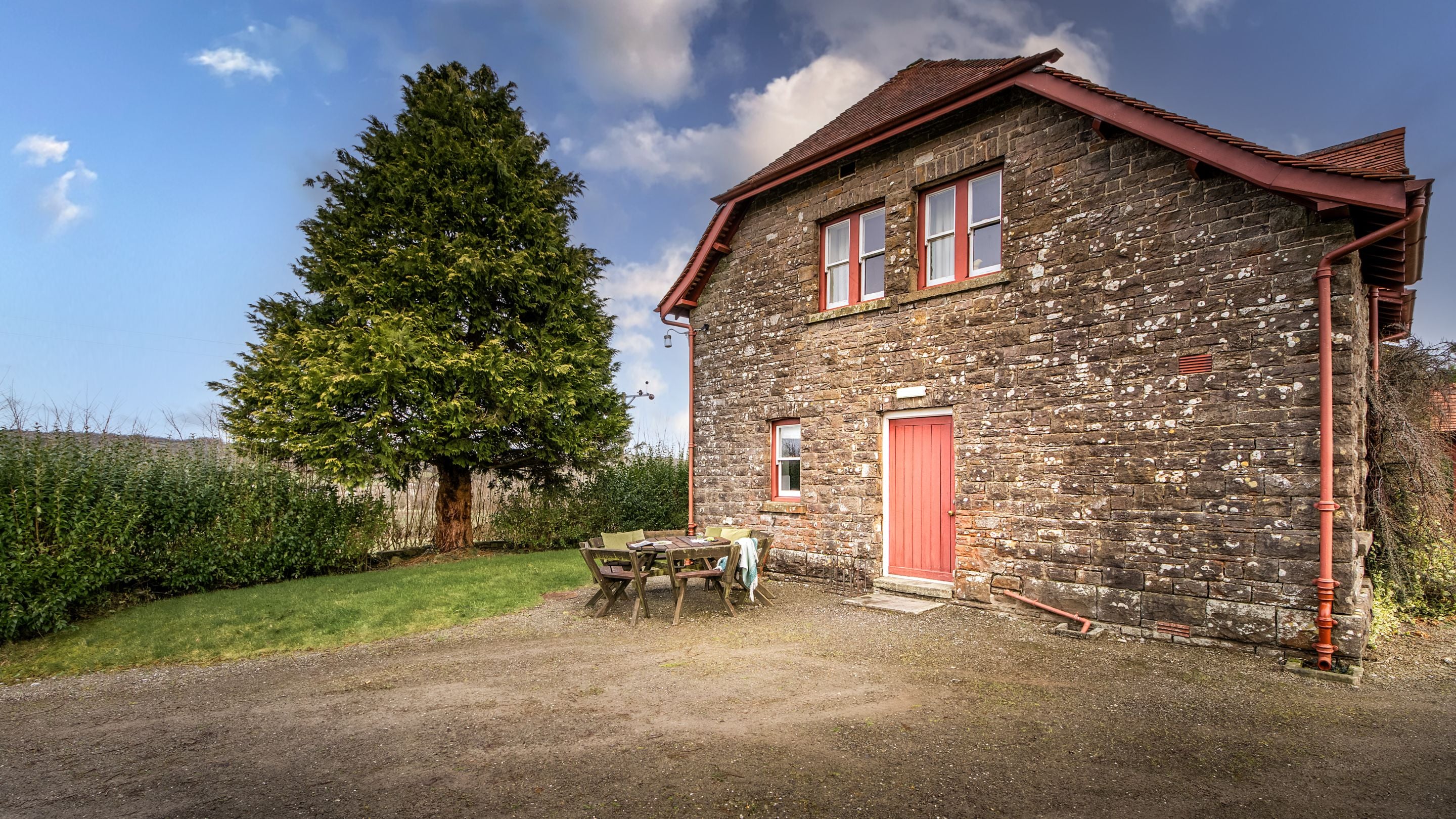 The side of Penparc, showing part of the garden and outdoor dining furniture, Carmarthenshire