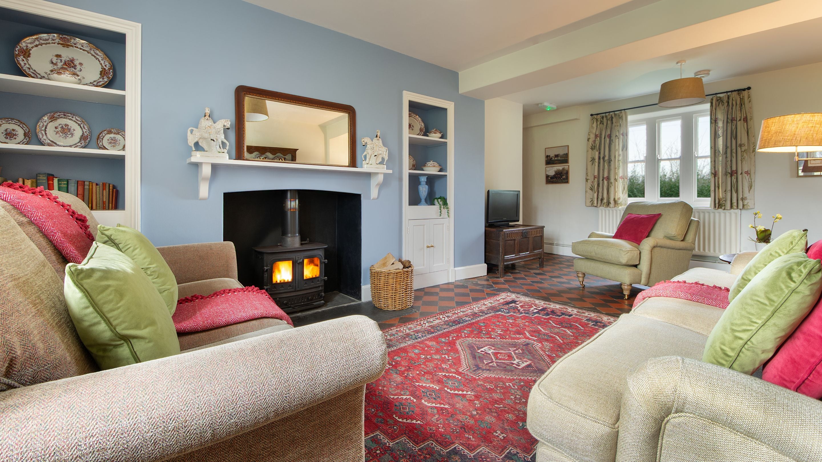The sitting room with woodburner, sofas, armchair and television at Penparc, Carmarthenshire
