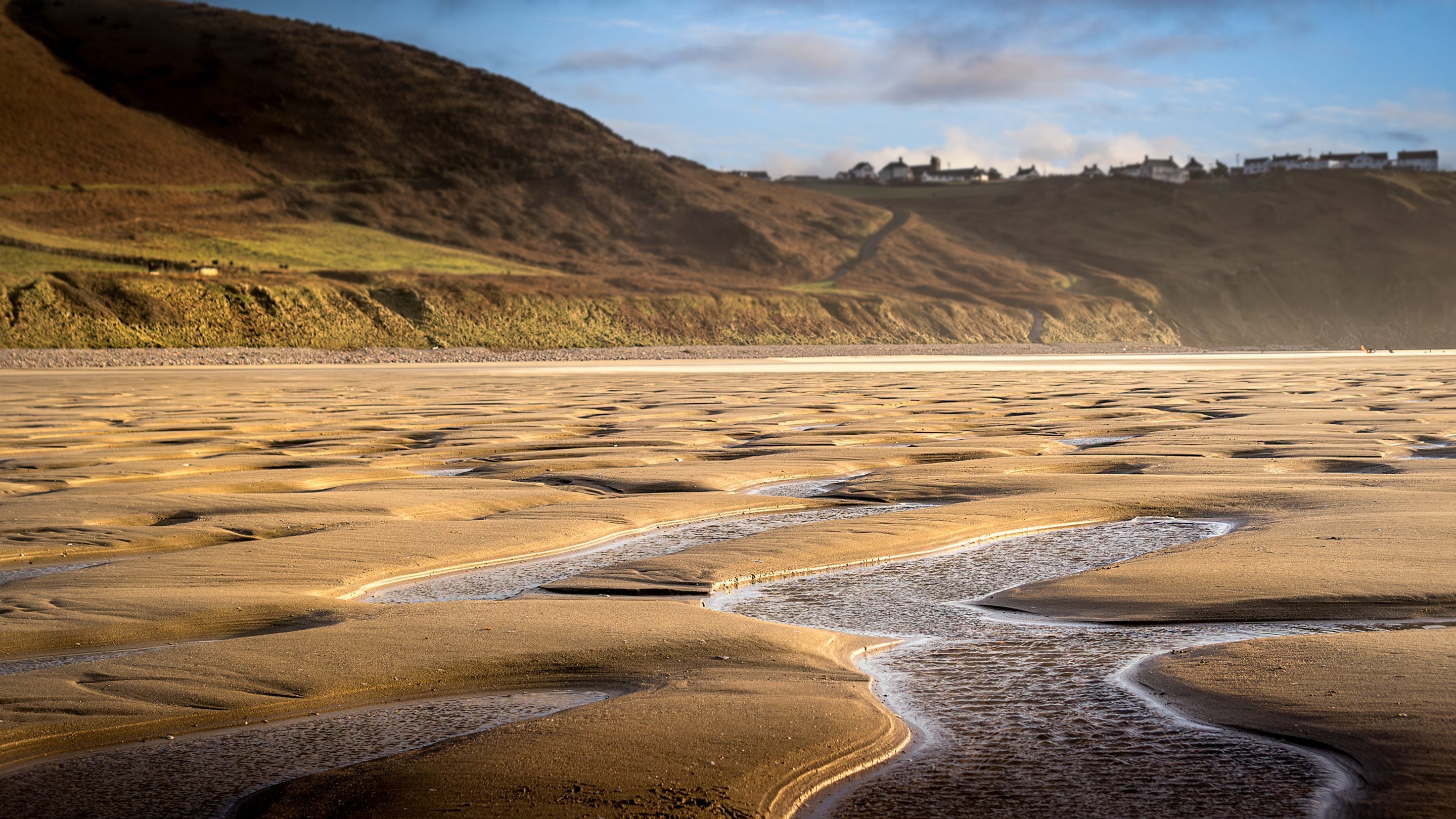 The golden sands of Rhossili Bay Beach with the hills of Rhossili Down in the background, near Rhossili Old Rectory, South Wales