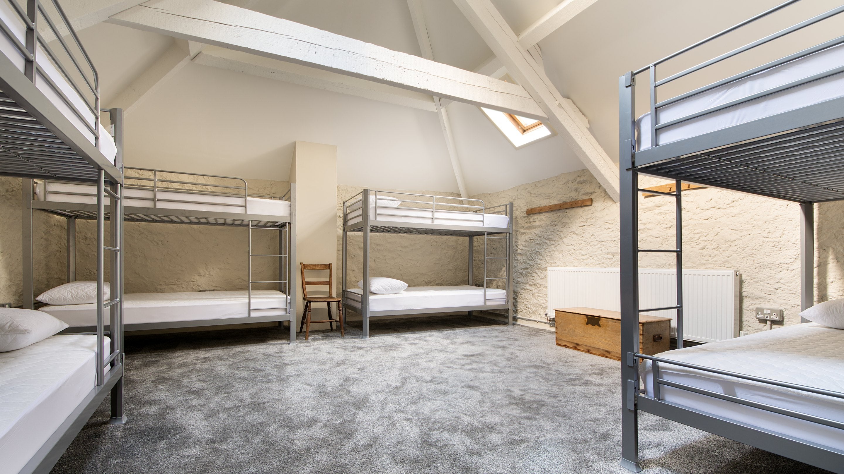 One of the bunkrooms with a vaulted ceiling and four bunkbeds, sleeping eight, at Watkin Bunkhouse, Gwynedd