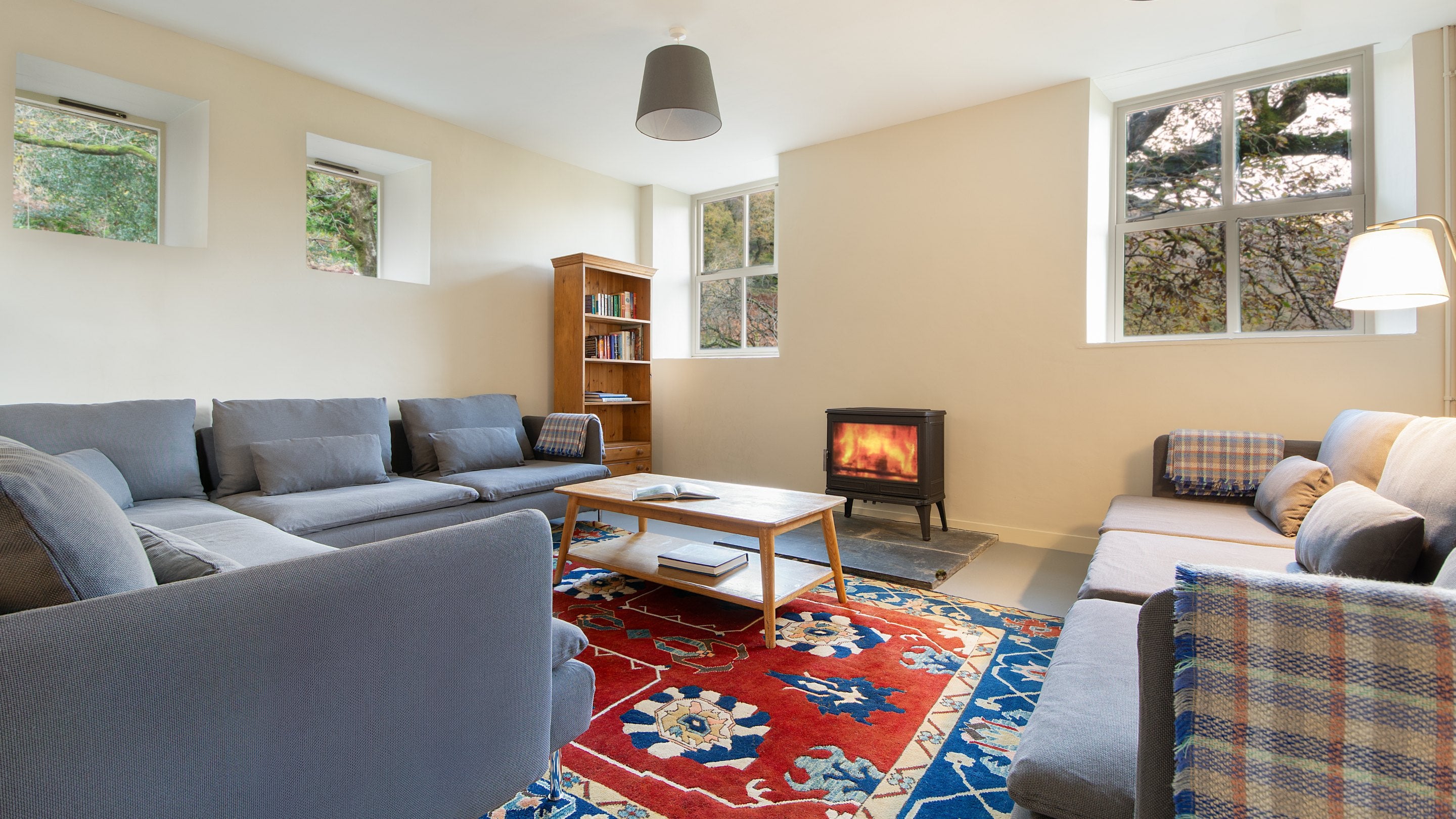 Part of the sitting room, with sofas, coffee table and woodburner, at Watkin Bunkhouse, Gwynedd