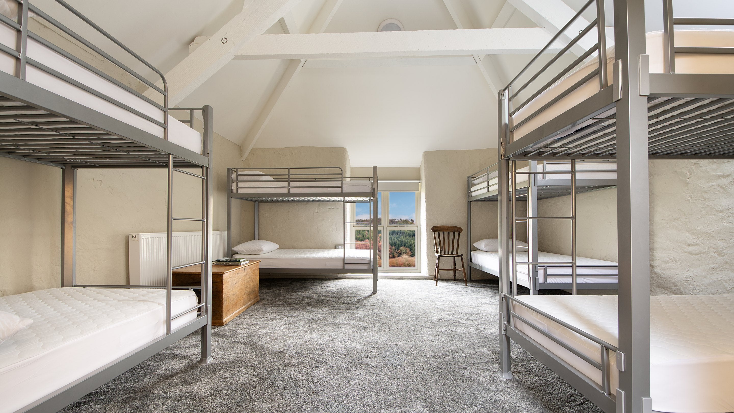 One of the bunkrooms with a vaulted ceiling and four bunkbeds, sleeping eight, at Watkin Bunkhouse, Gwynedd
