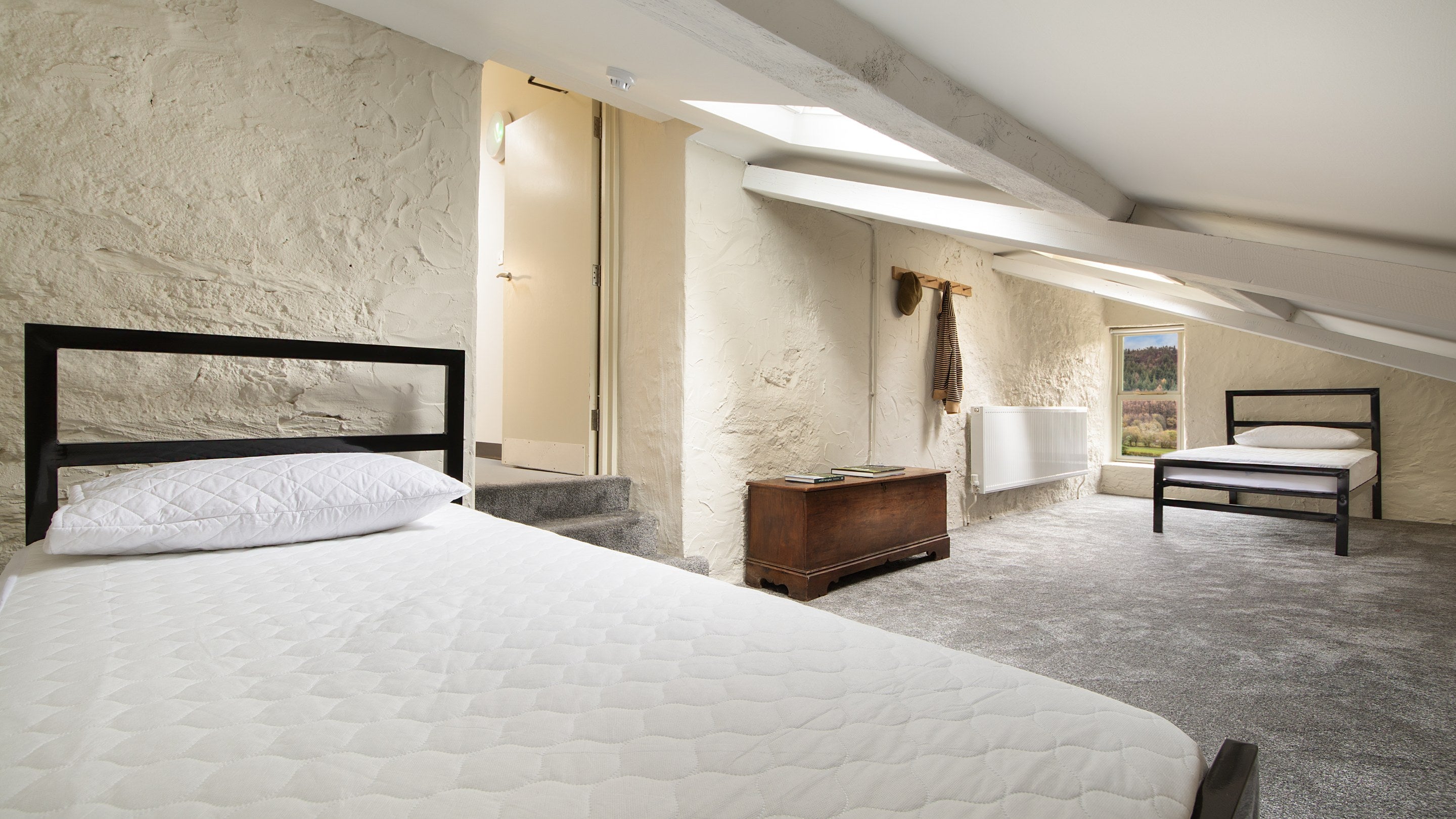 The twin bedroom, with sloping ceiling, on the first floor of Watkin Bunkhouse, Gwynedd