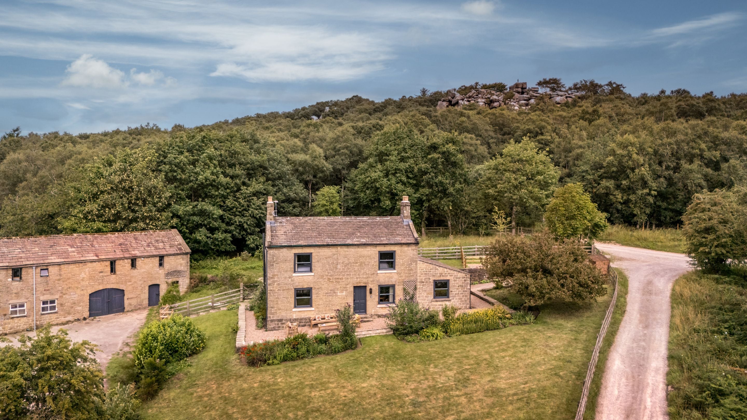 An aerial view of Druid's Cave Farmhouse and part of Brimham Rocks at the top of the hill behind, North Yorkshire