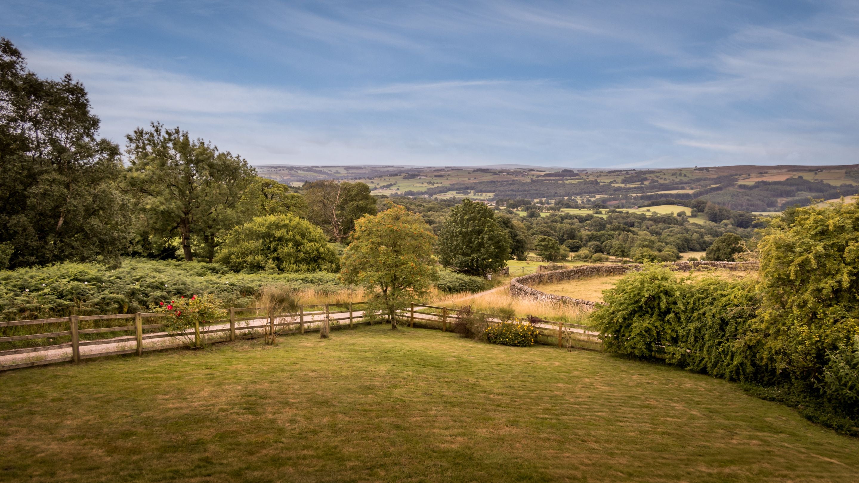 An aerial view of the garden lawn at Druid's Cave Farmhouse, with views over Nidderdale beyond, North Yorkshire