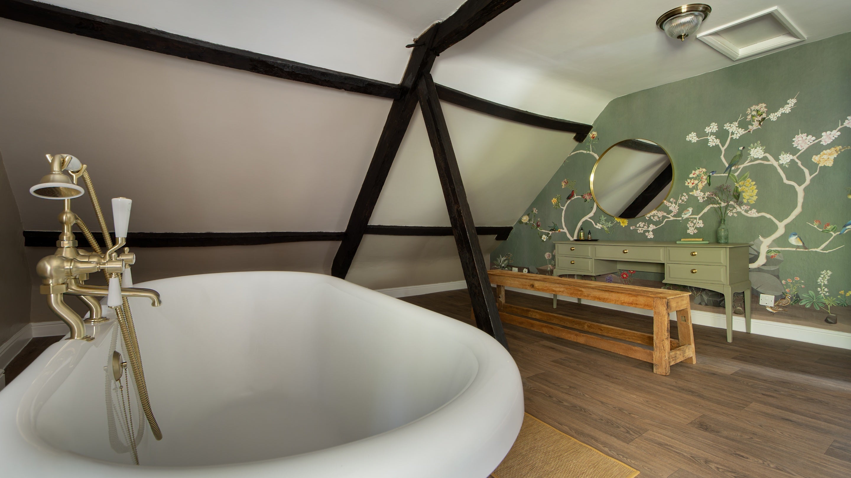 The large second-floor bathroom at Fountains Cottage, with roll-top bath and floral mural wallpaper, Yorkshire