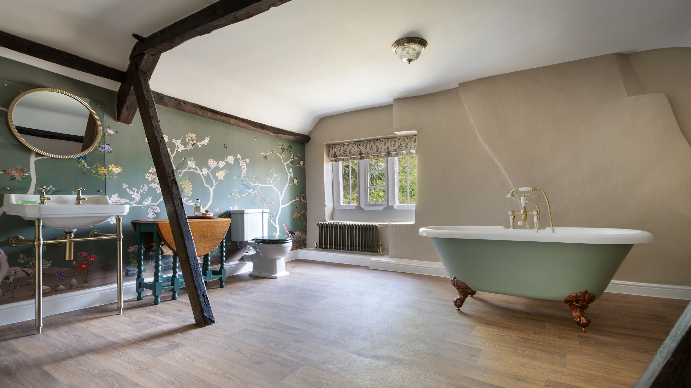 The large second-floor bathroom at Fountains Cottage, with roll-top bath and floral mural wallpaper, Yorkshire