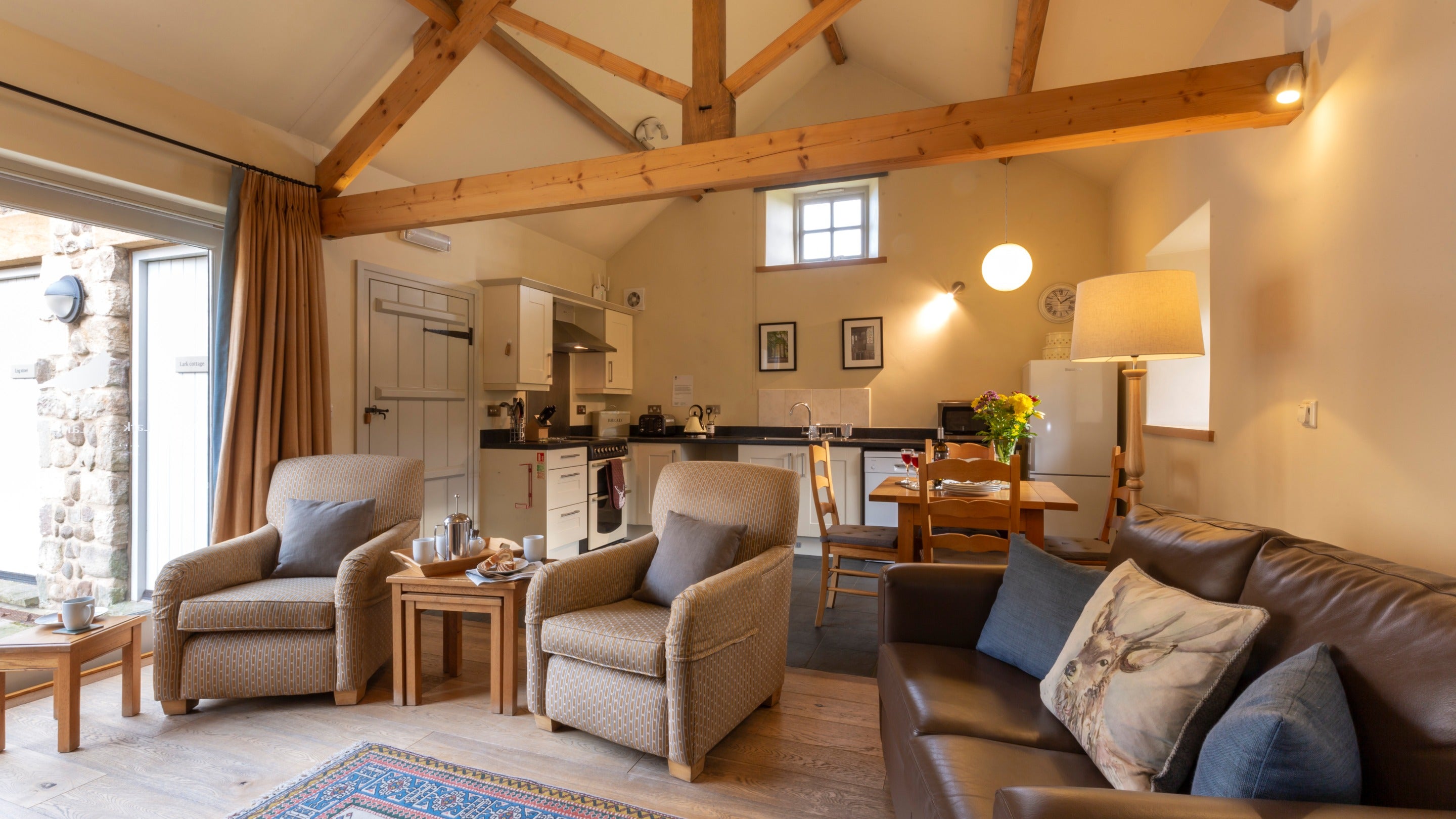 The open-plan kitchen, dining and sitting room at Lark, with exposed beams and vaulted ceiling, Yorkshire