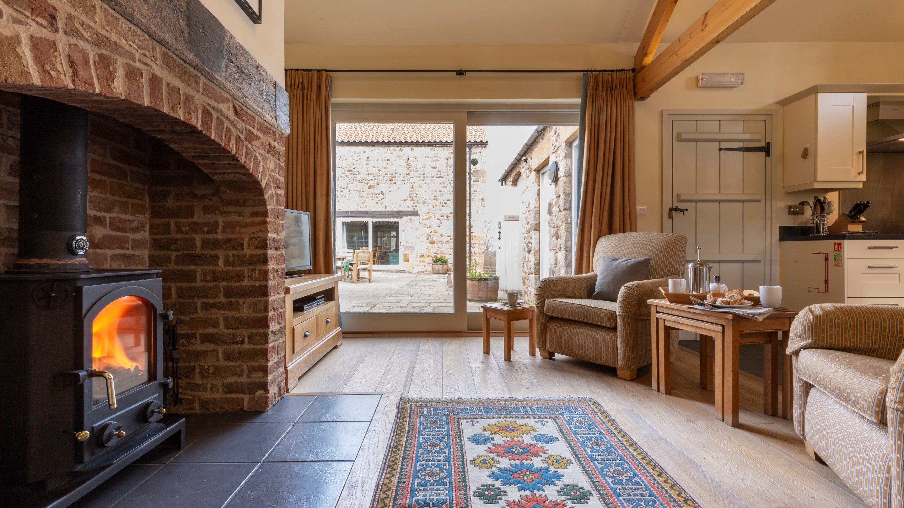 The woodburner in the open-plan kitchen, dining and sitting room at Lark, Yorkshire