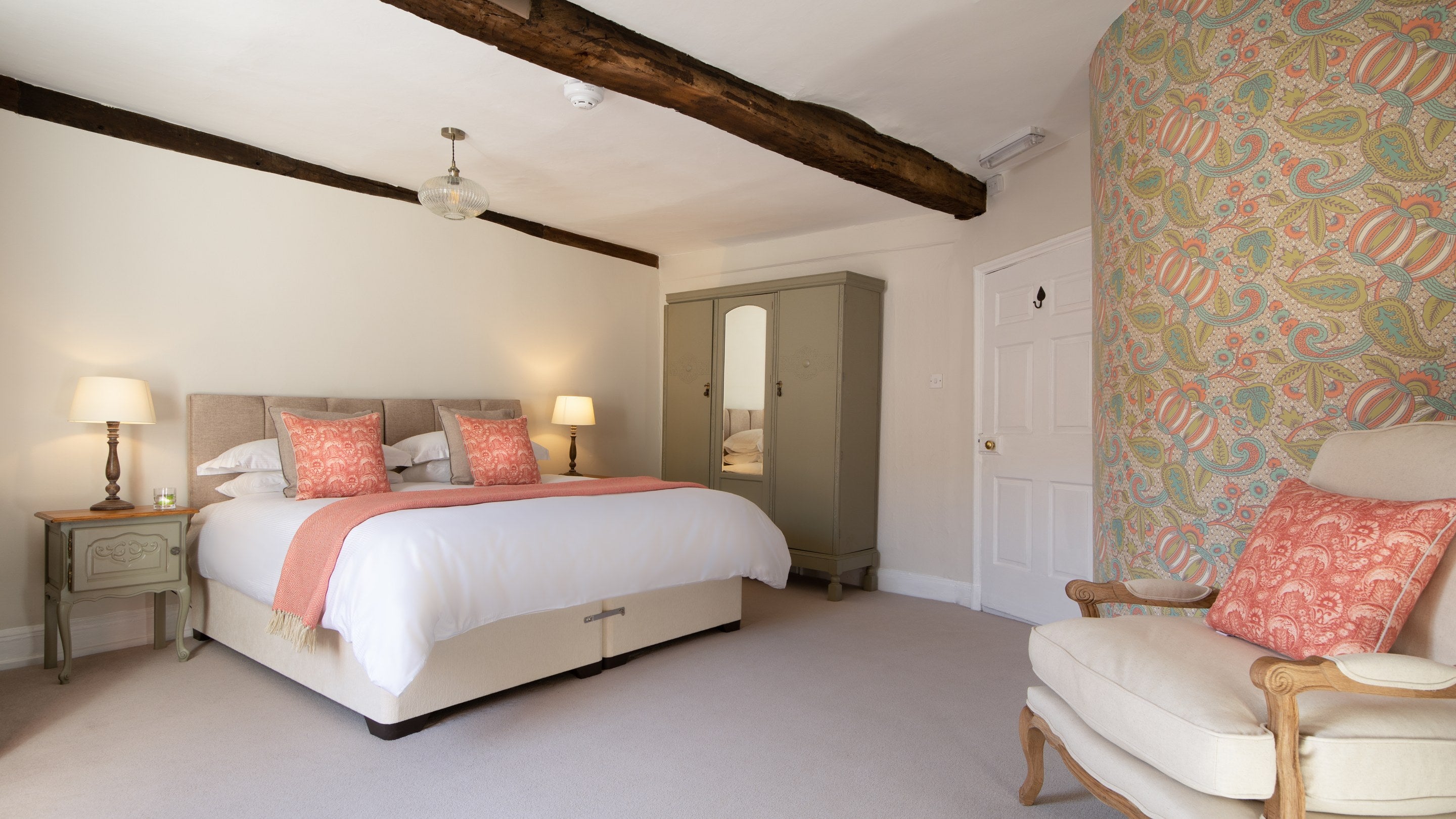 The bedroom at Minstergate with a king-size bed (which can be made into a twin on request), wardrobe, armchair and original beams, Yorkshire