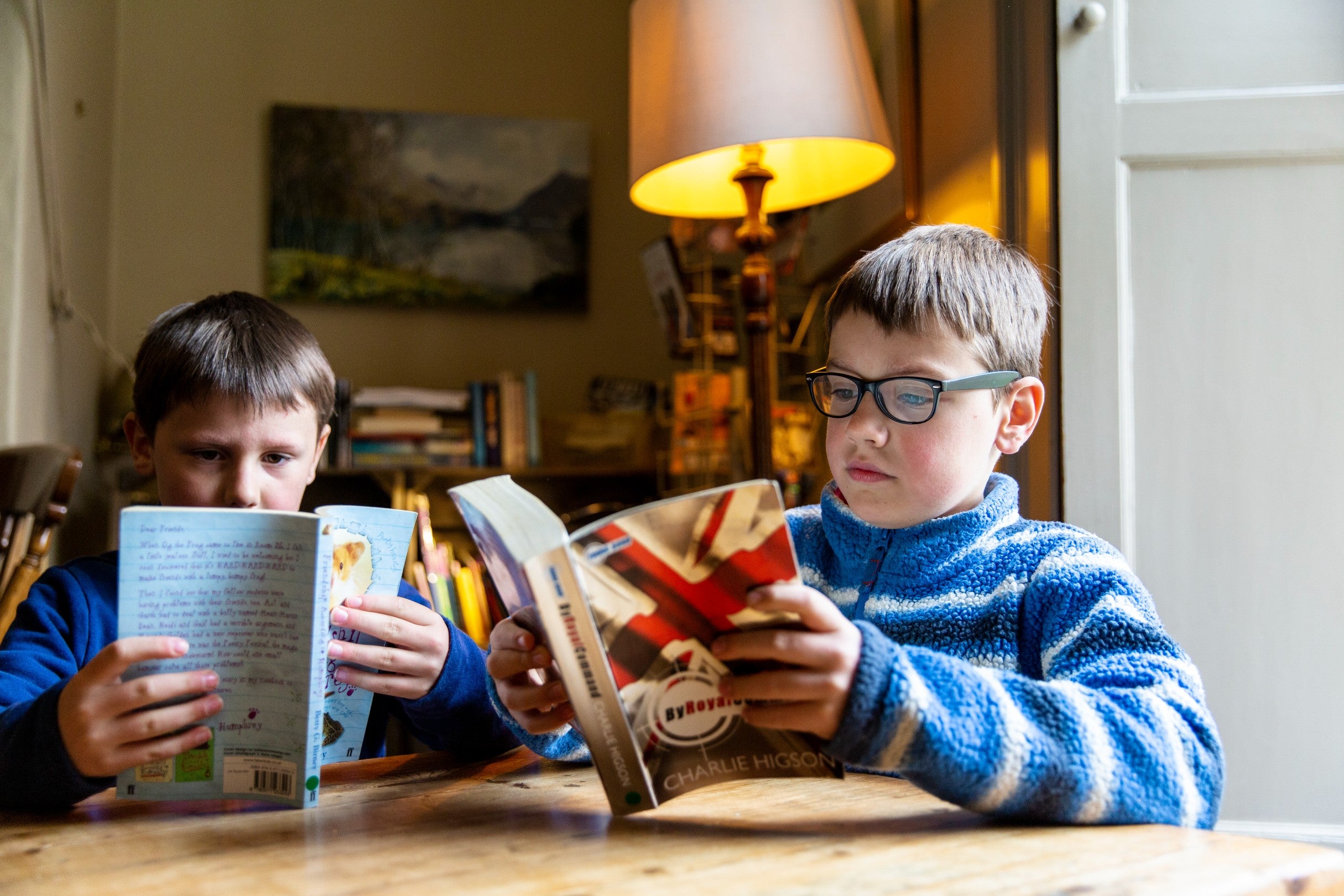 Children reading in the second hand bookshop at Allan Bank and Grasmere, Cumbria.