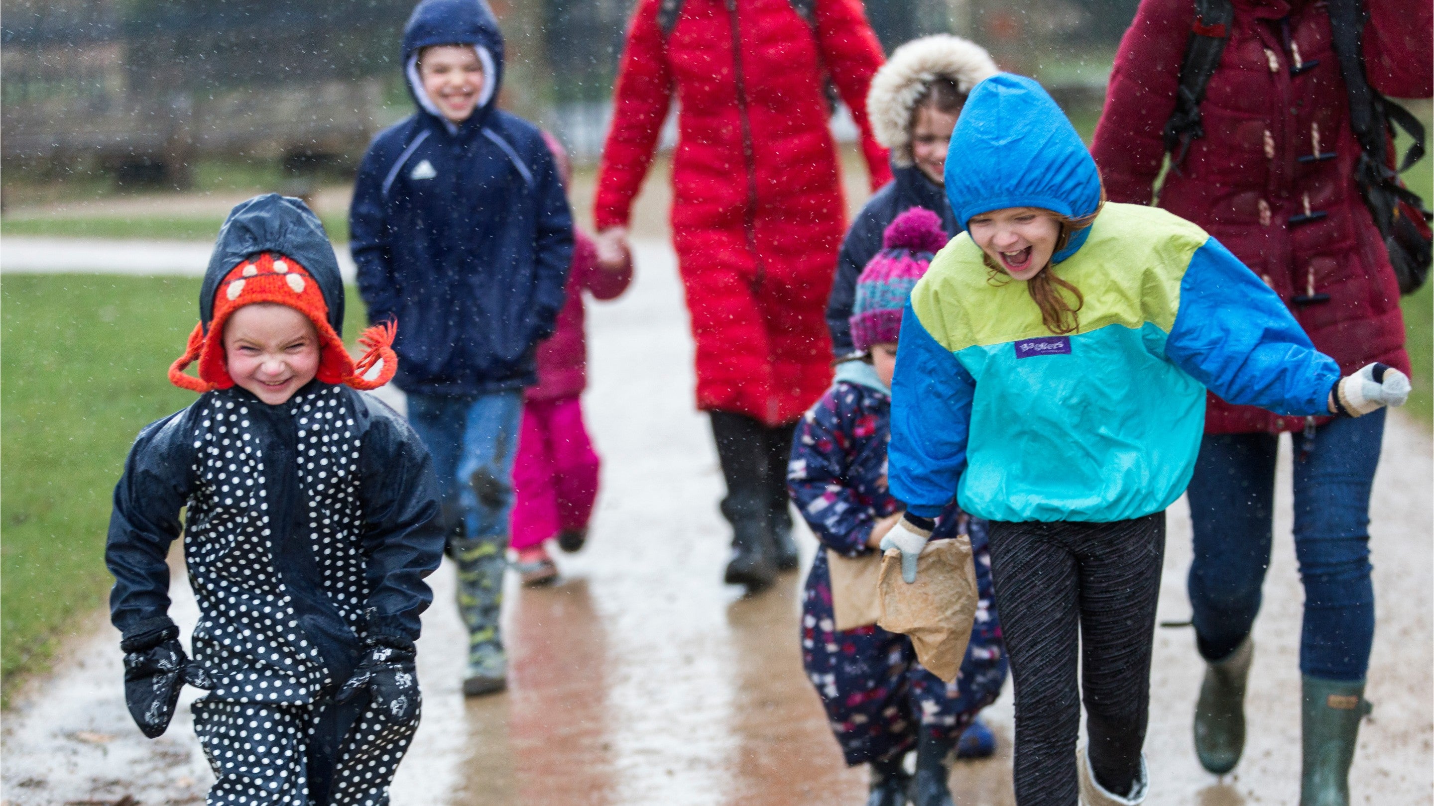 Children running towards the camera in the rain at Charlecote Park, Warwickshire