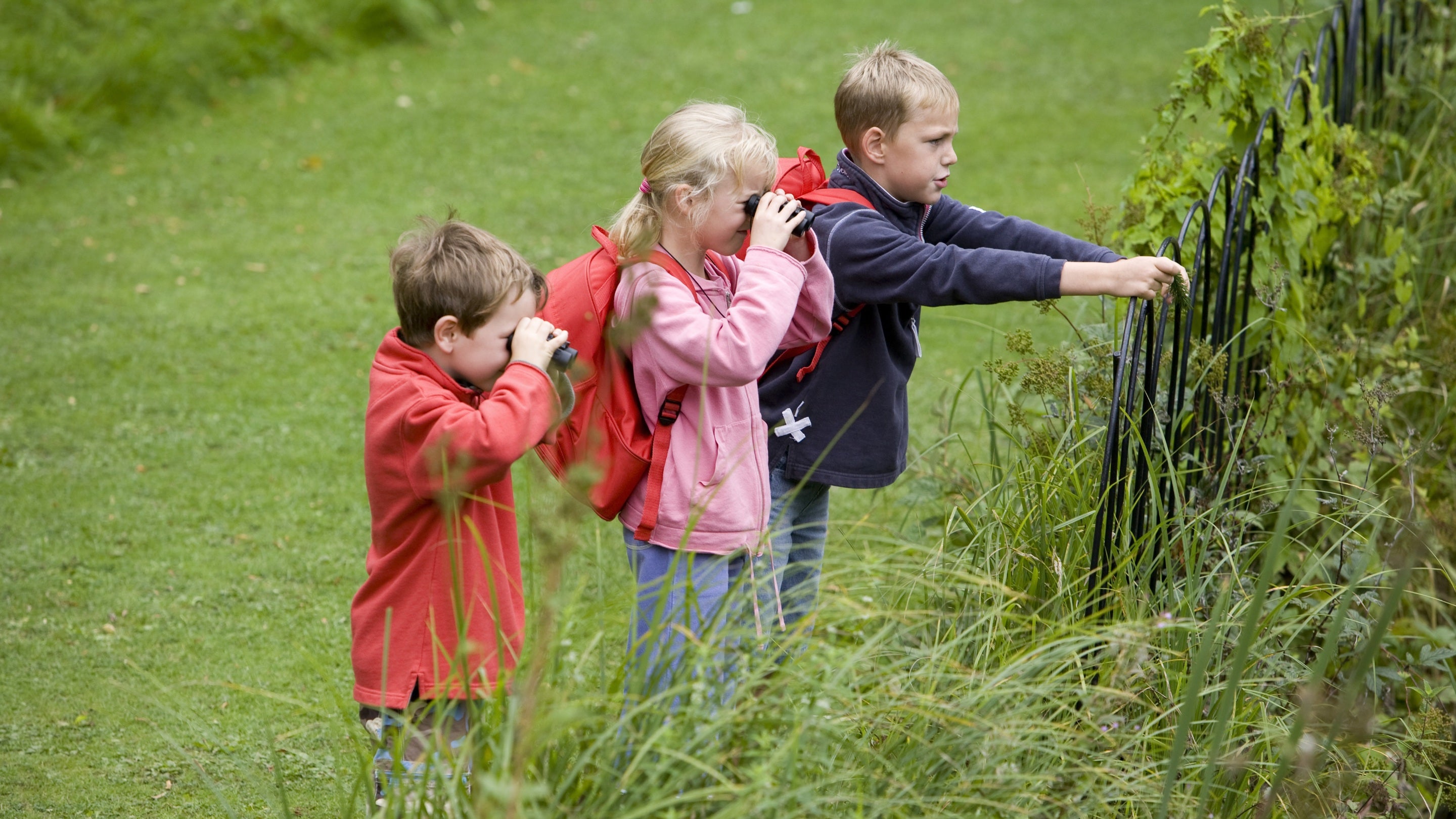 Children taking a close look at the borders in the garden at Anglesey Abbey, Cambridgeshire