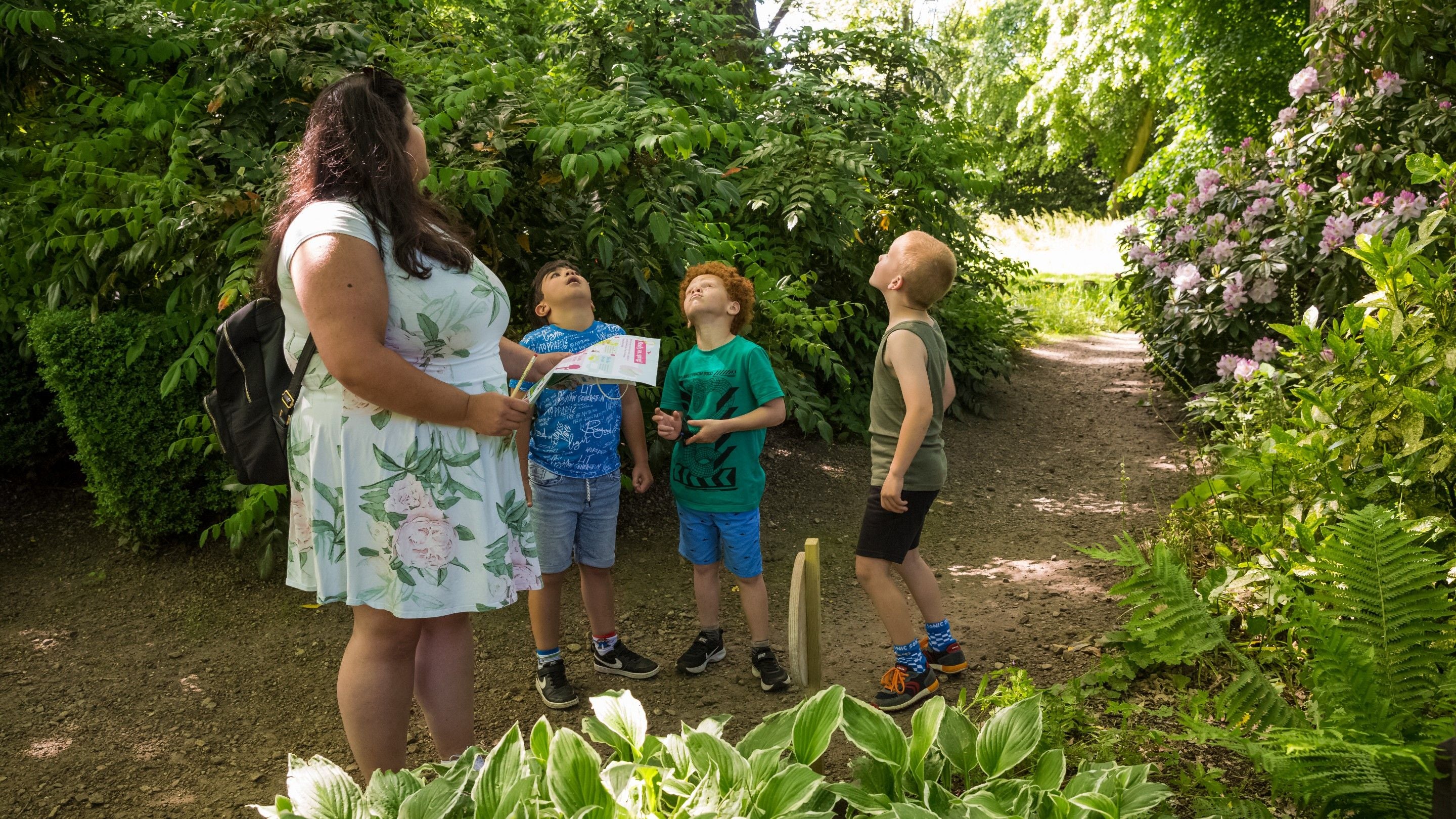 An adult and three children look up on a path at Rufford Old Hall, Lancashire