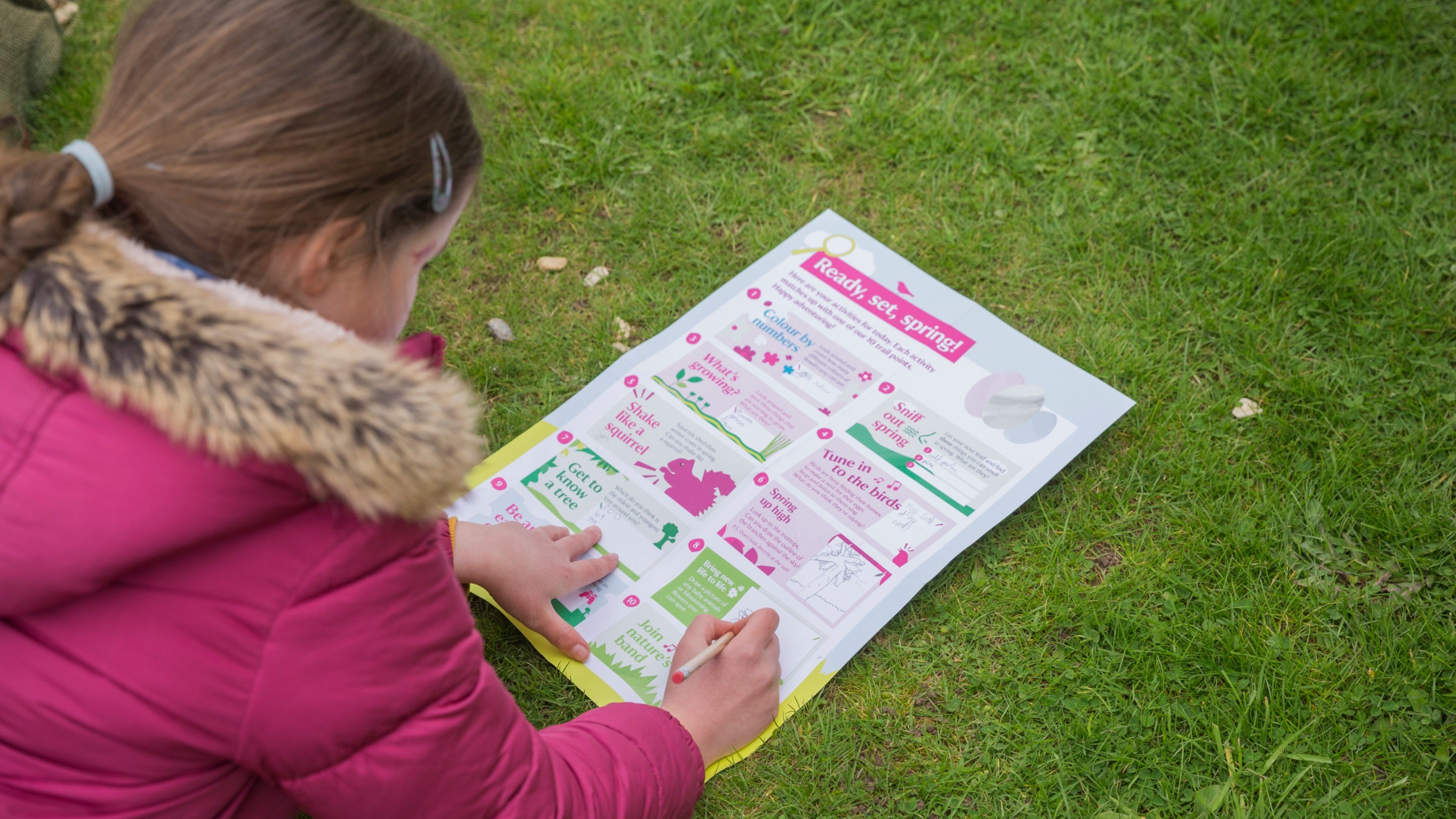 Young girl laying on lawn filling in Easter trail pack