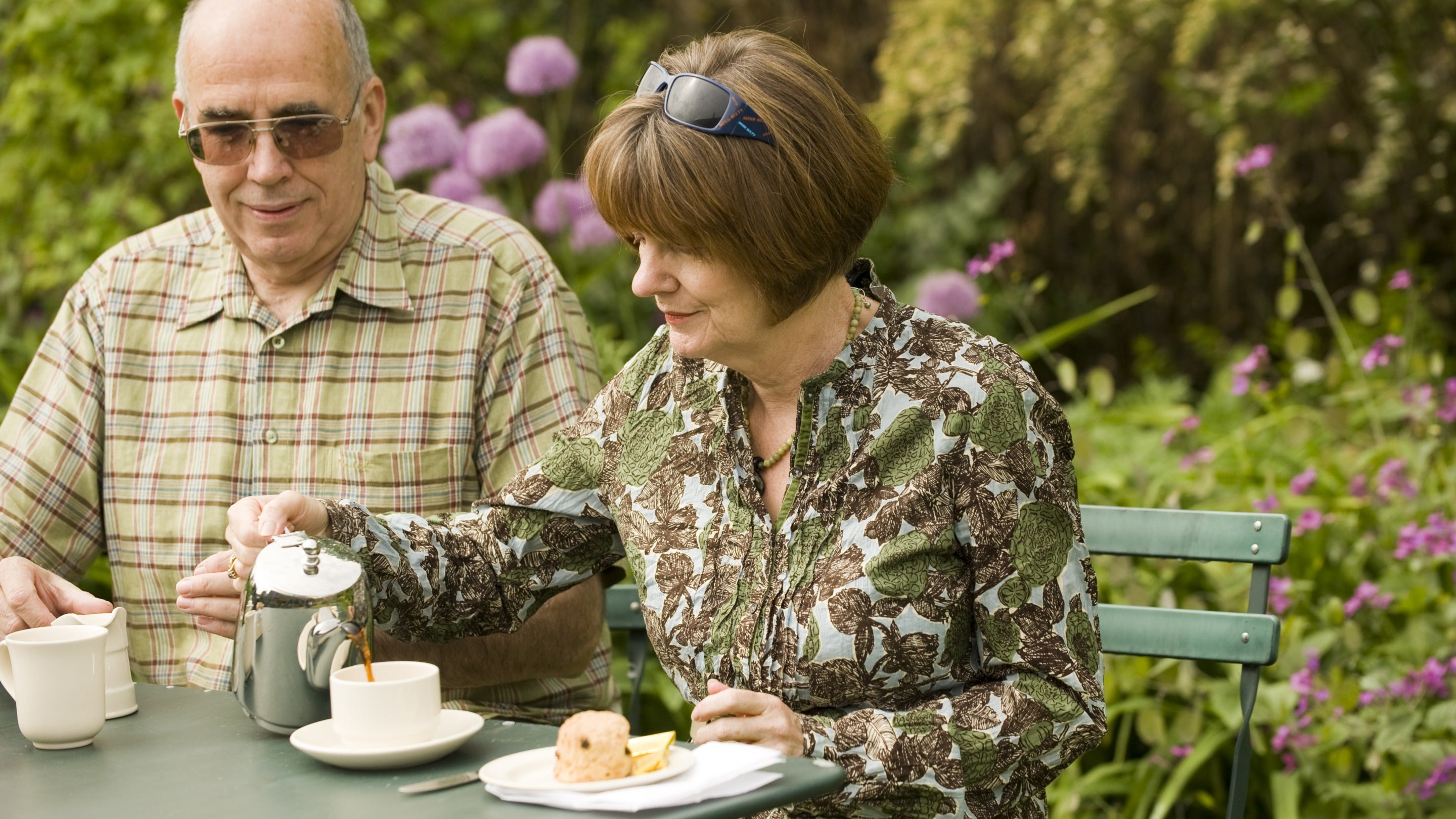 Visitors sit outside having tea and scones in the cafe tea garden at Canons Ashby, Northamptonshire