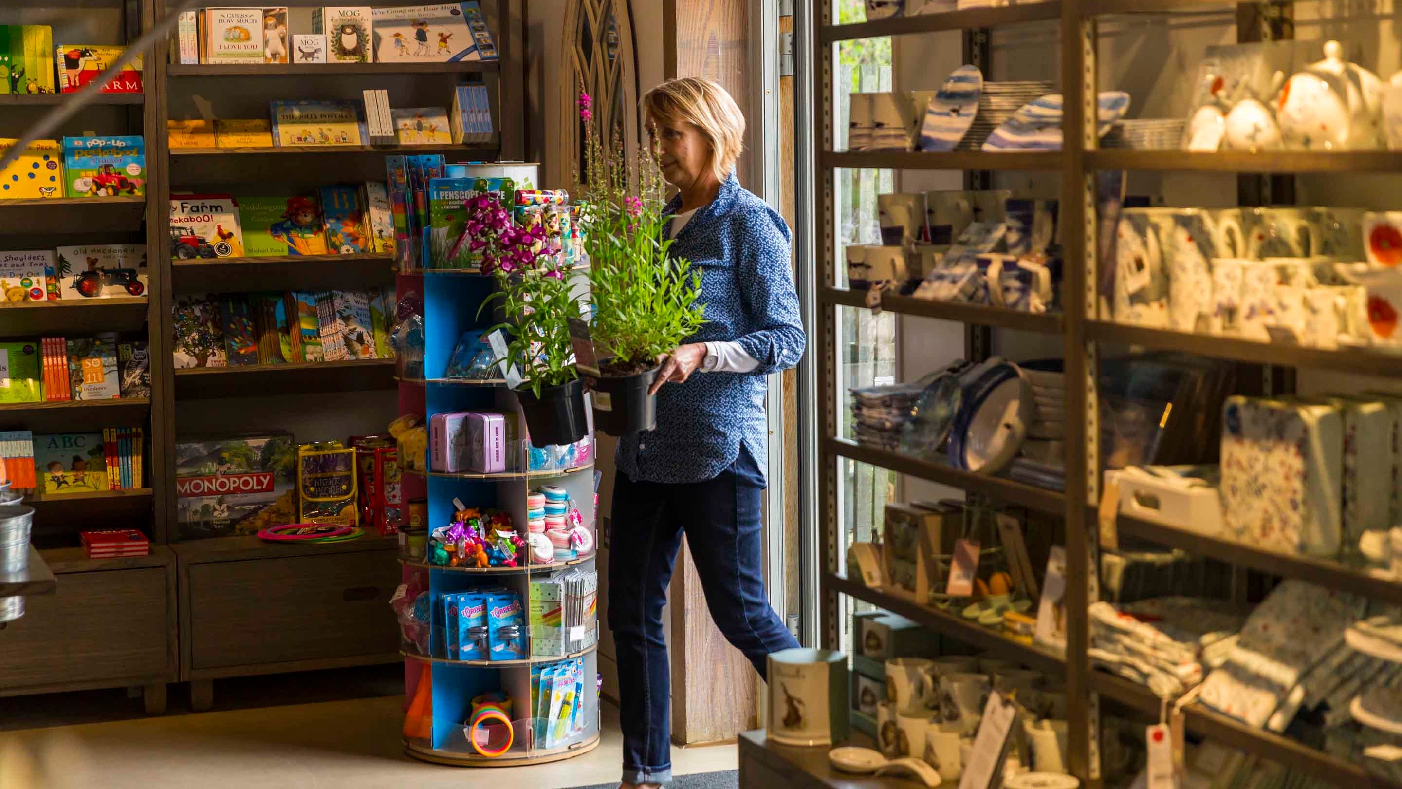 Visitor carrying two plants into the shop