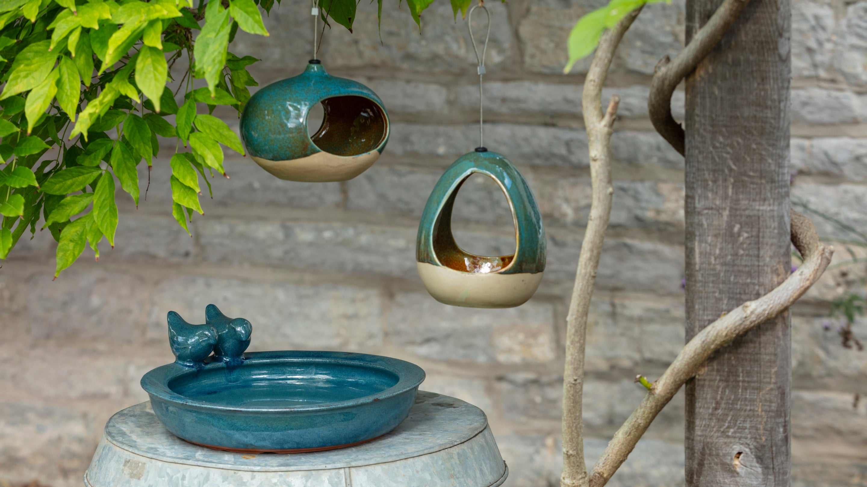 A blue bird bath and bird feeders