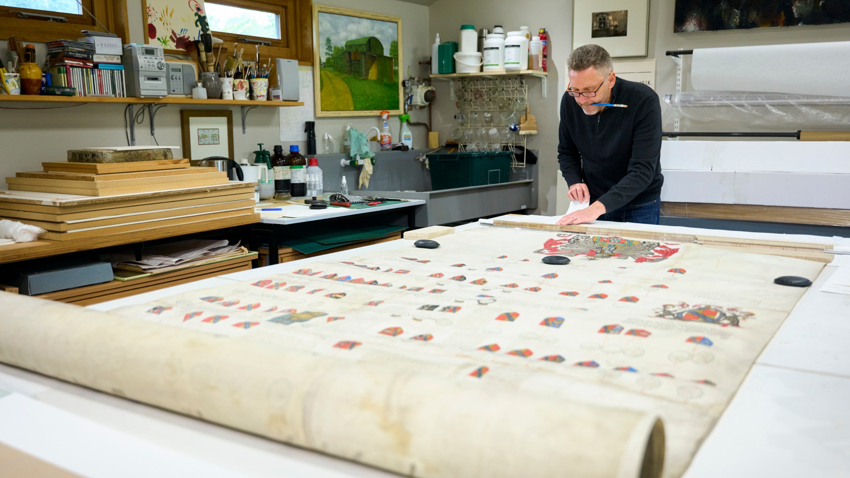 Someone working on the large parchment of the Sackville Family Patents and Pedigrees from Knole at The Studio, Langley Cottage, Cambridgeshire