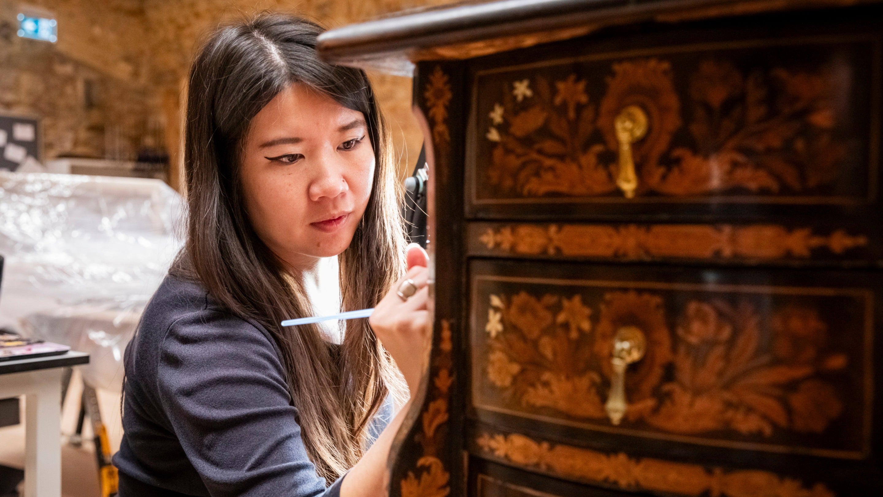 Conservation work on an ornate chest of drawers being filmed for the Hidden Treasures of the National Trust Series 3