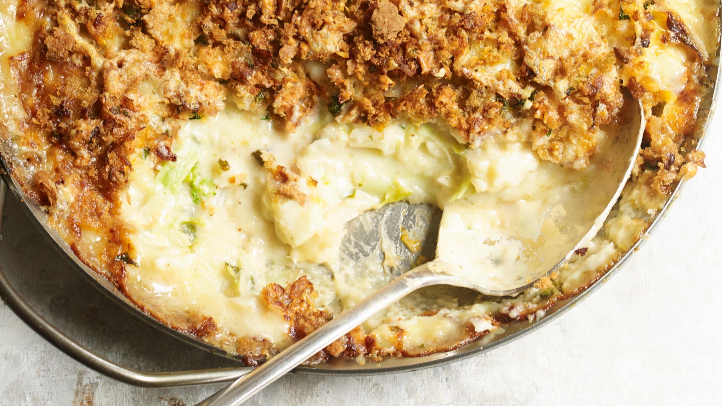 Dish of baked cauliflower gratin with a spoon
