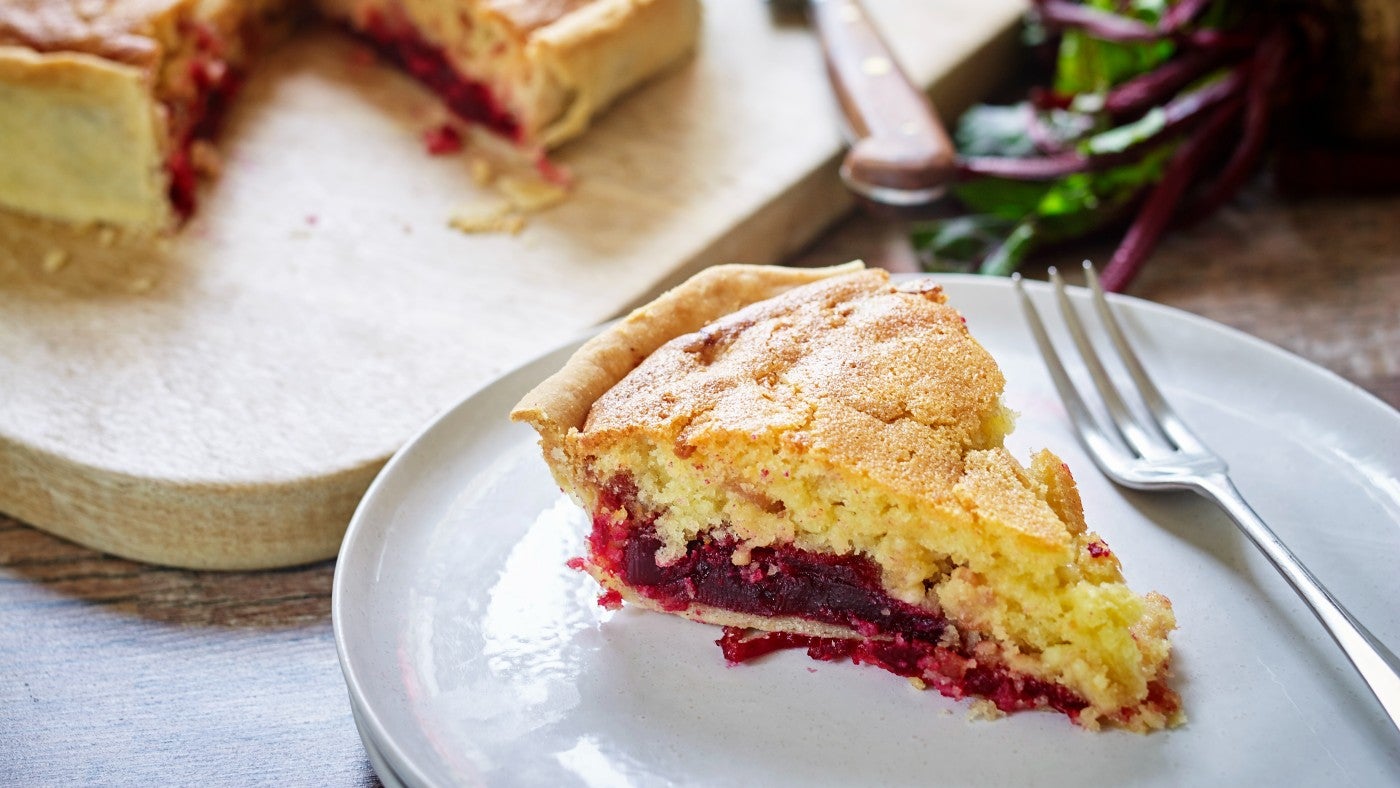 A slice of beetroot, bacon and cheese cake on a plate
