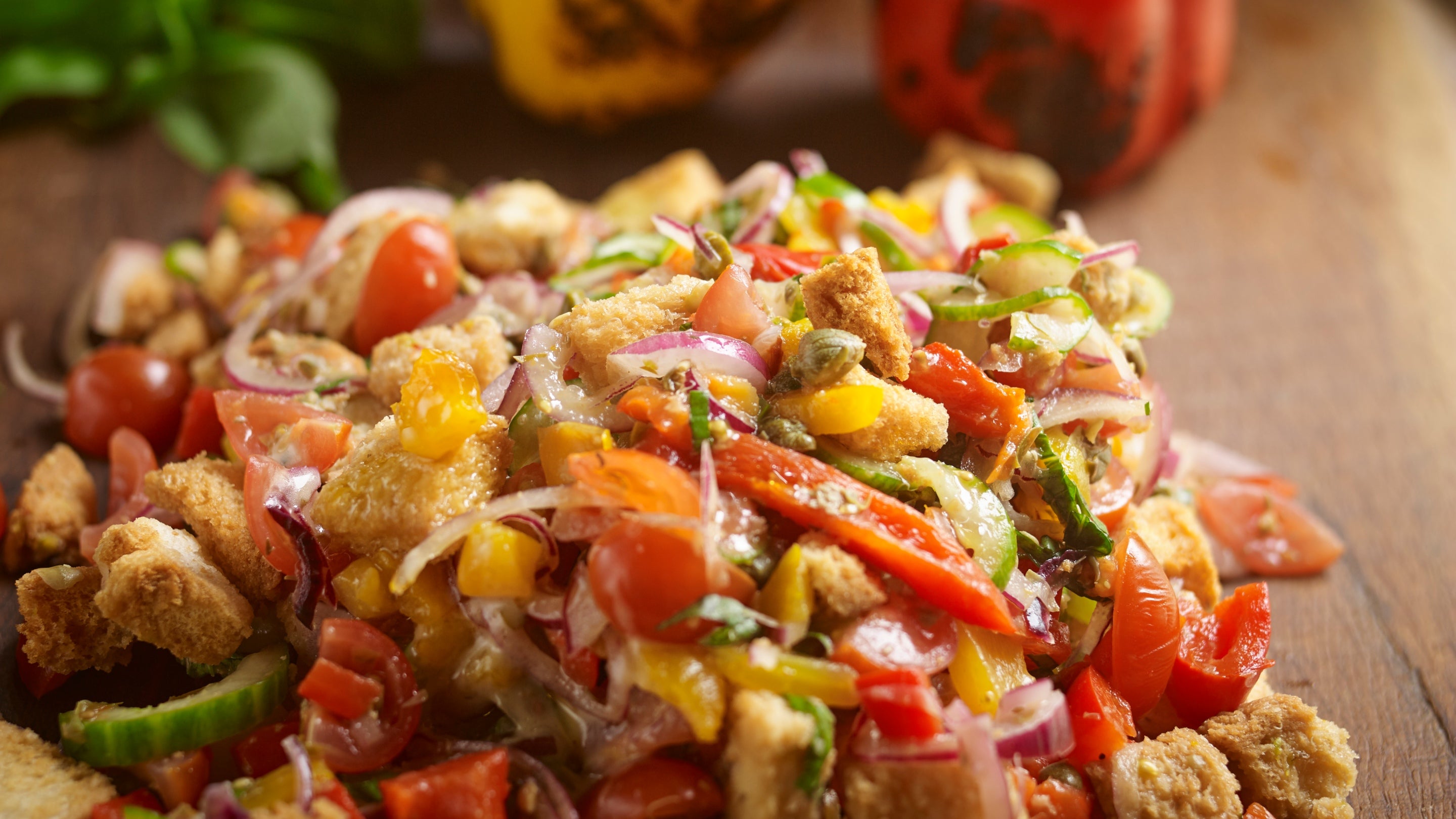A deliciously fresh pananella salad on a plate with peppers
