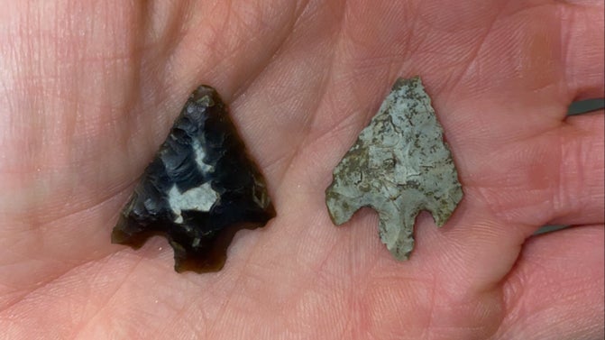 A close-up of two arrowheads placed on a hand