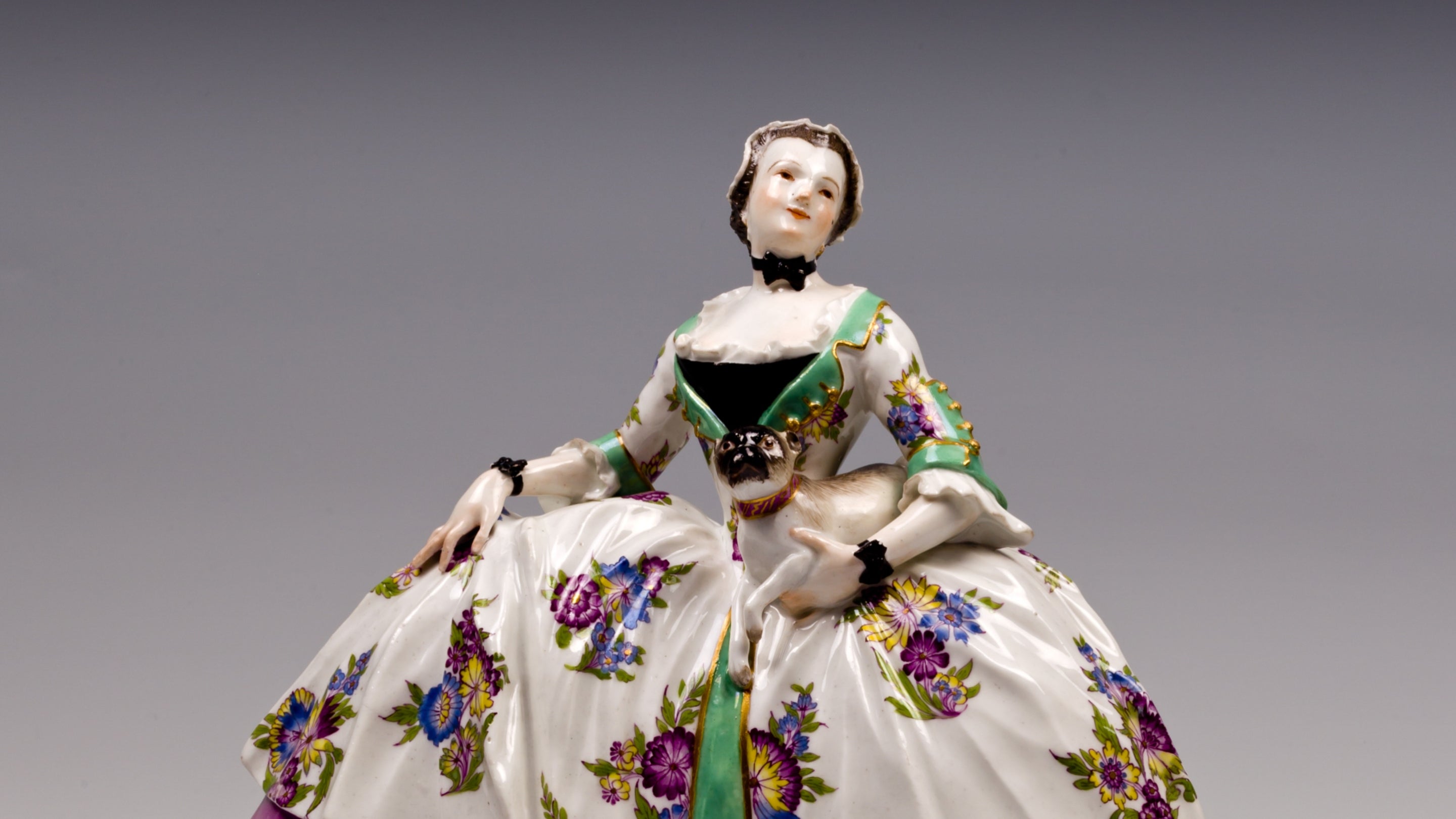 The Lady of the Order of the Pug, a porcelain figure of a woman in a large dress posing