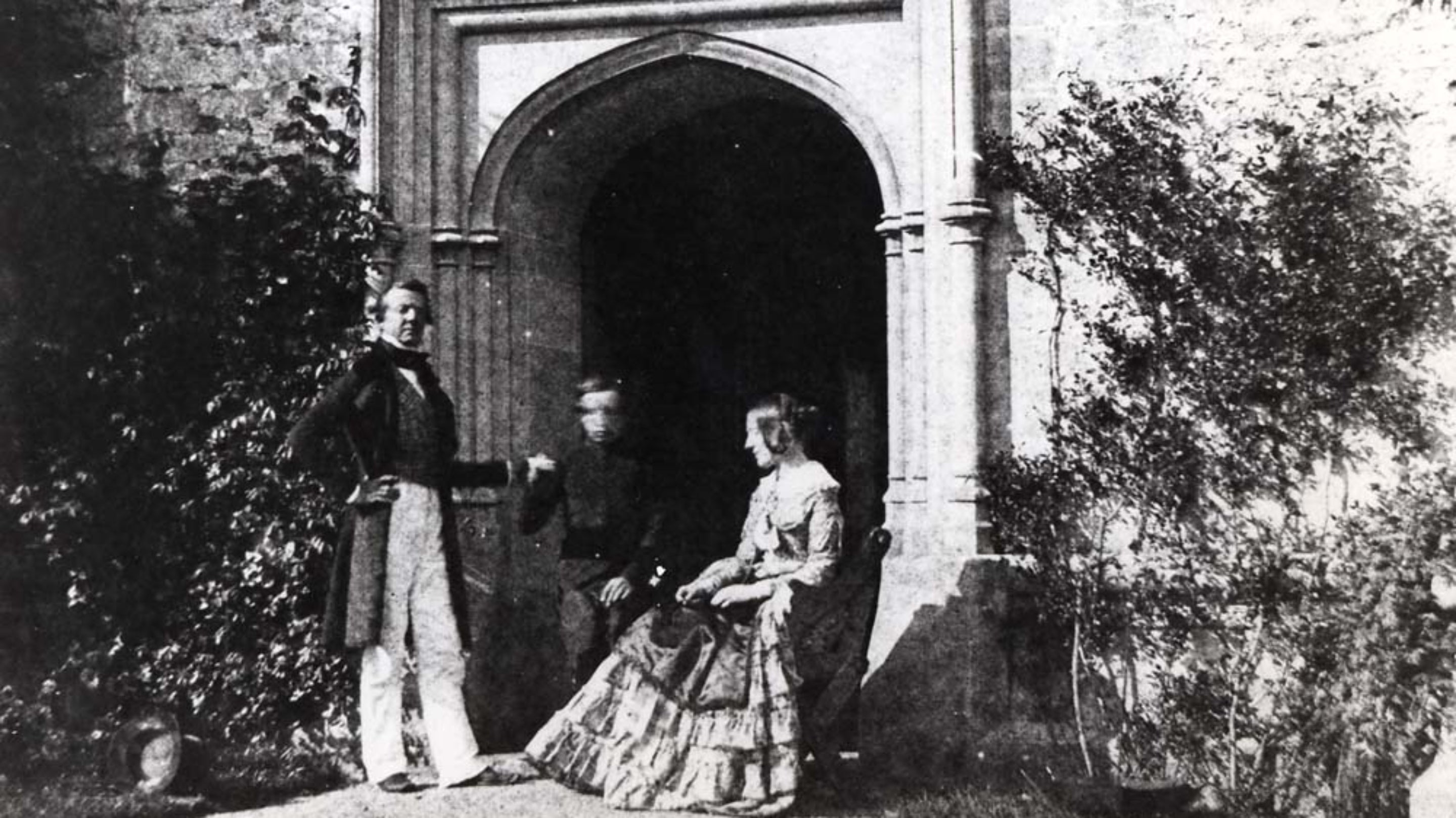 A modern positive image made via a calotype paper negative by William Henry Fox Talbot of his family outside the entrance to the Cloisters, Lacock Abbey, Wiltshire