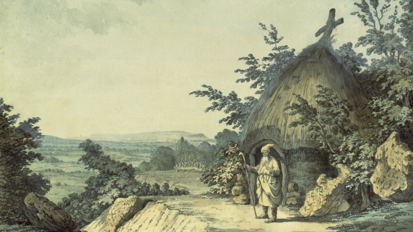 A painting of an old man carrying a stick standing outside a small, round, thatched building with a cross on the top, surrounded by trees and set in a pastoral landscape with hills in the distance.