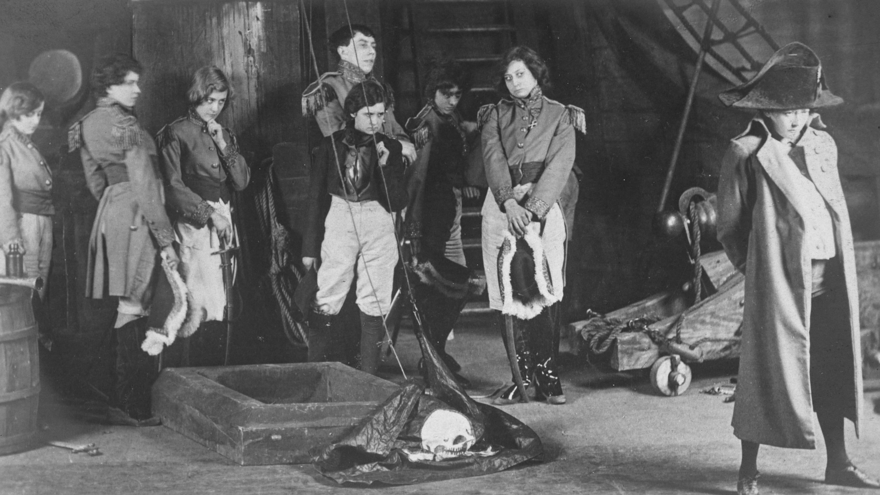 A black and white image of a group of performers on stage in costume