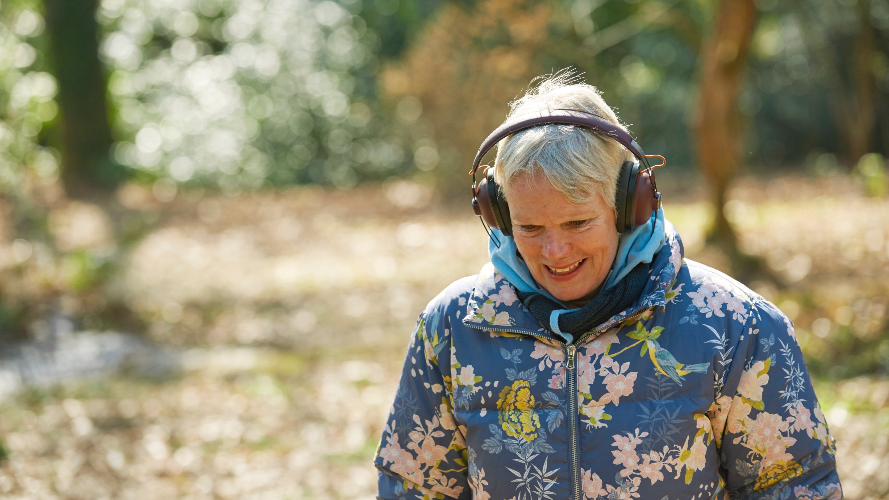 Visitor listening to headphones and walking in the grounds at Knightshayes, Devon