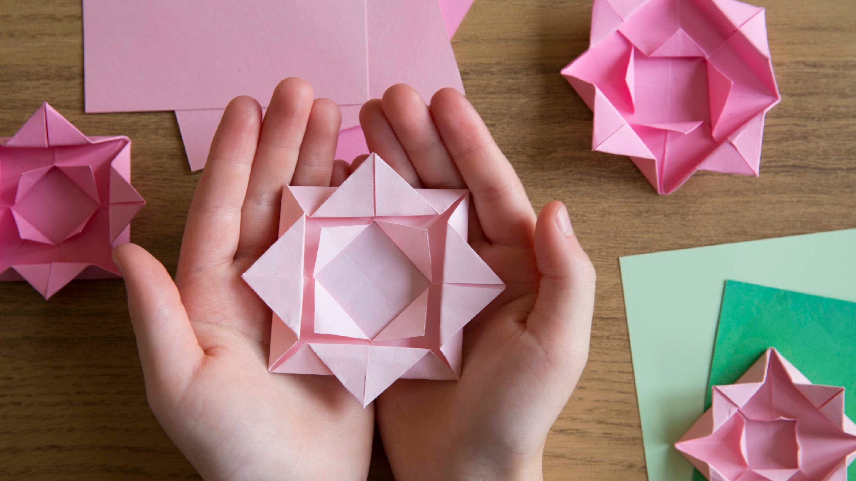 A child holds a folded origami flower