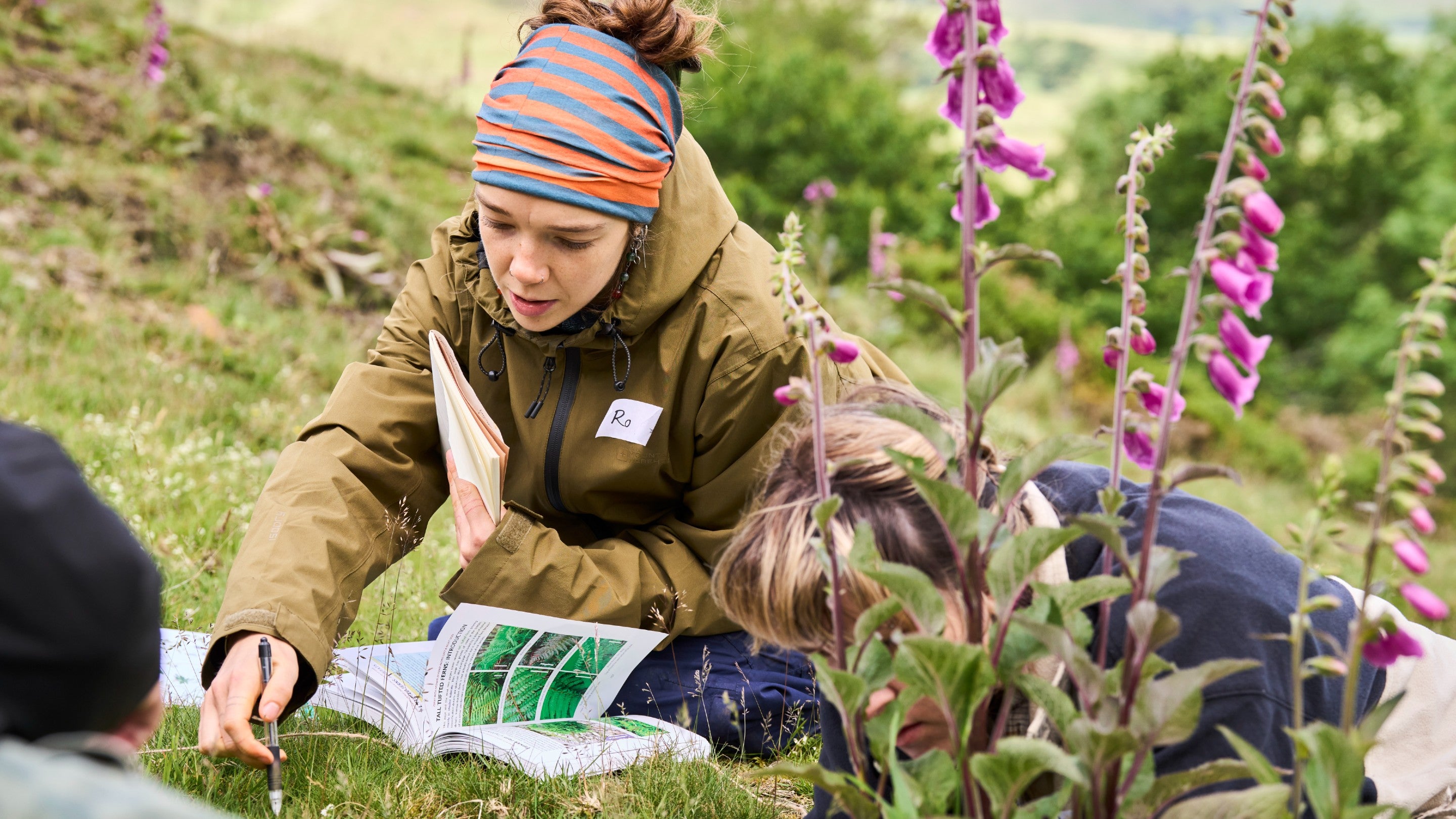 Two young people using a field guide at Dalehead, Peak District