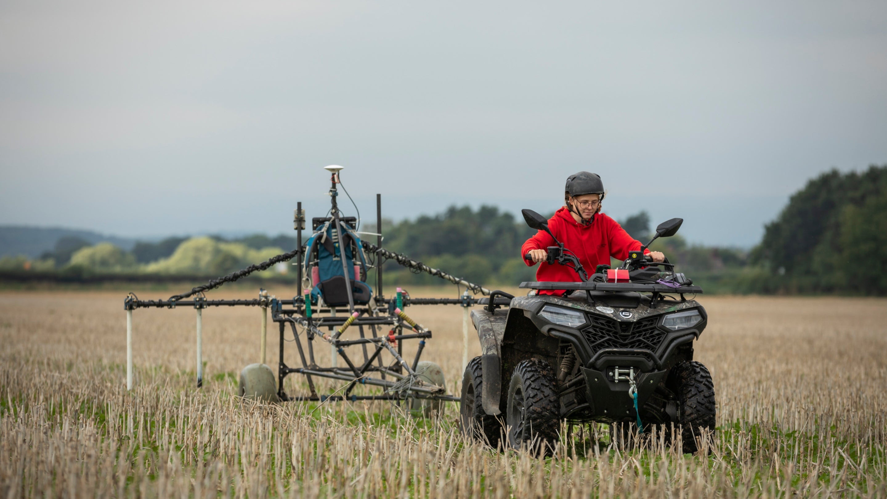Archaeologist carrying out geophysical survey on a quadbike through a field