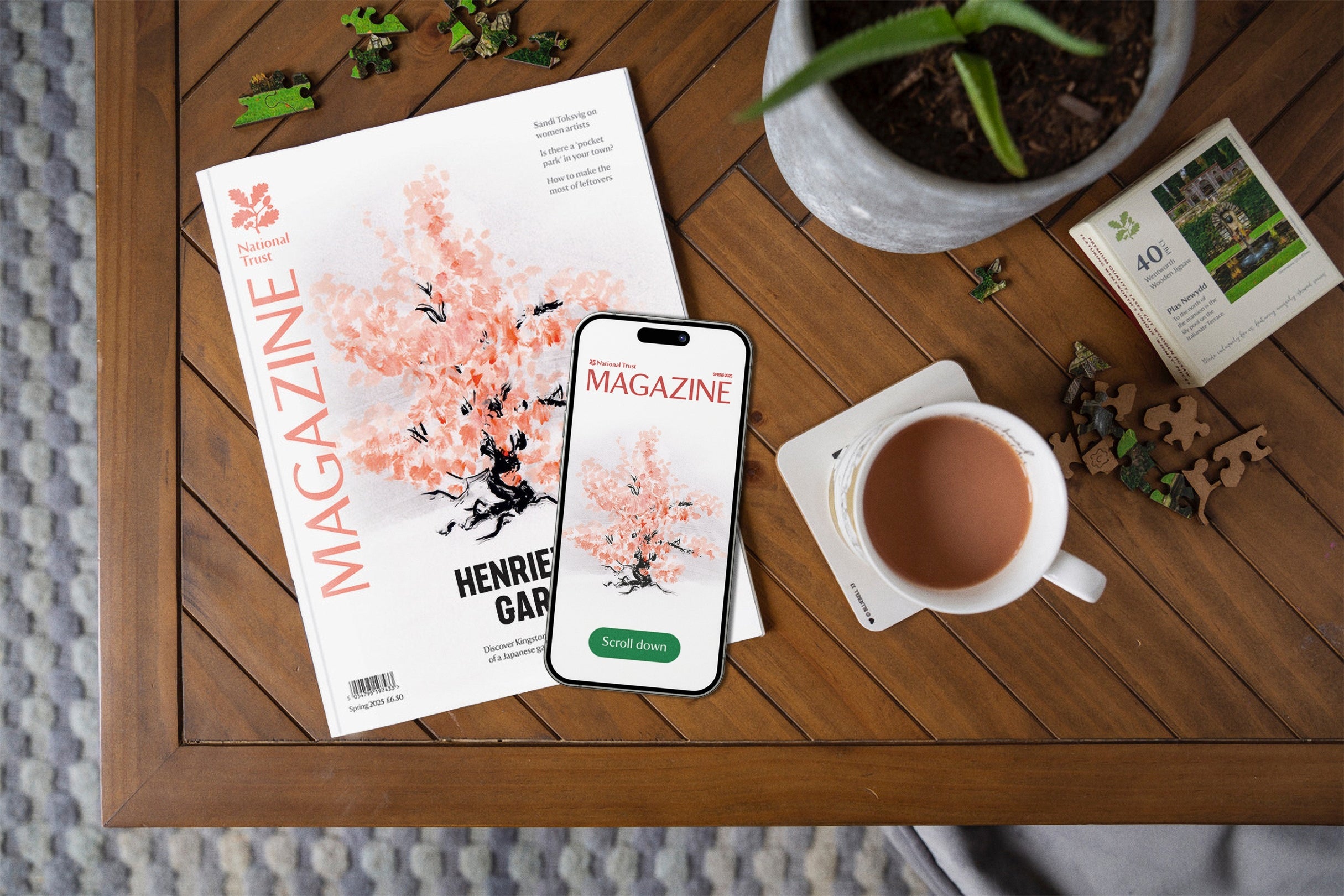 A copy of the National Trust spring 2025 Magazine on a table and a phone showing the digital edition