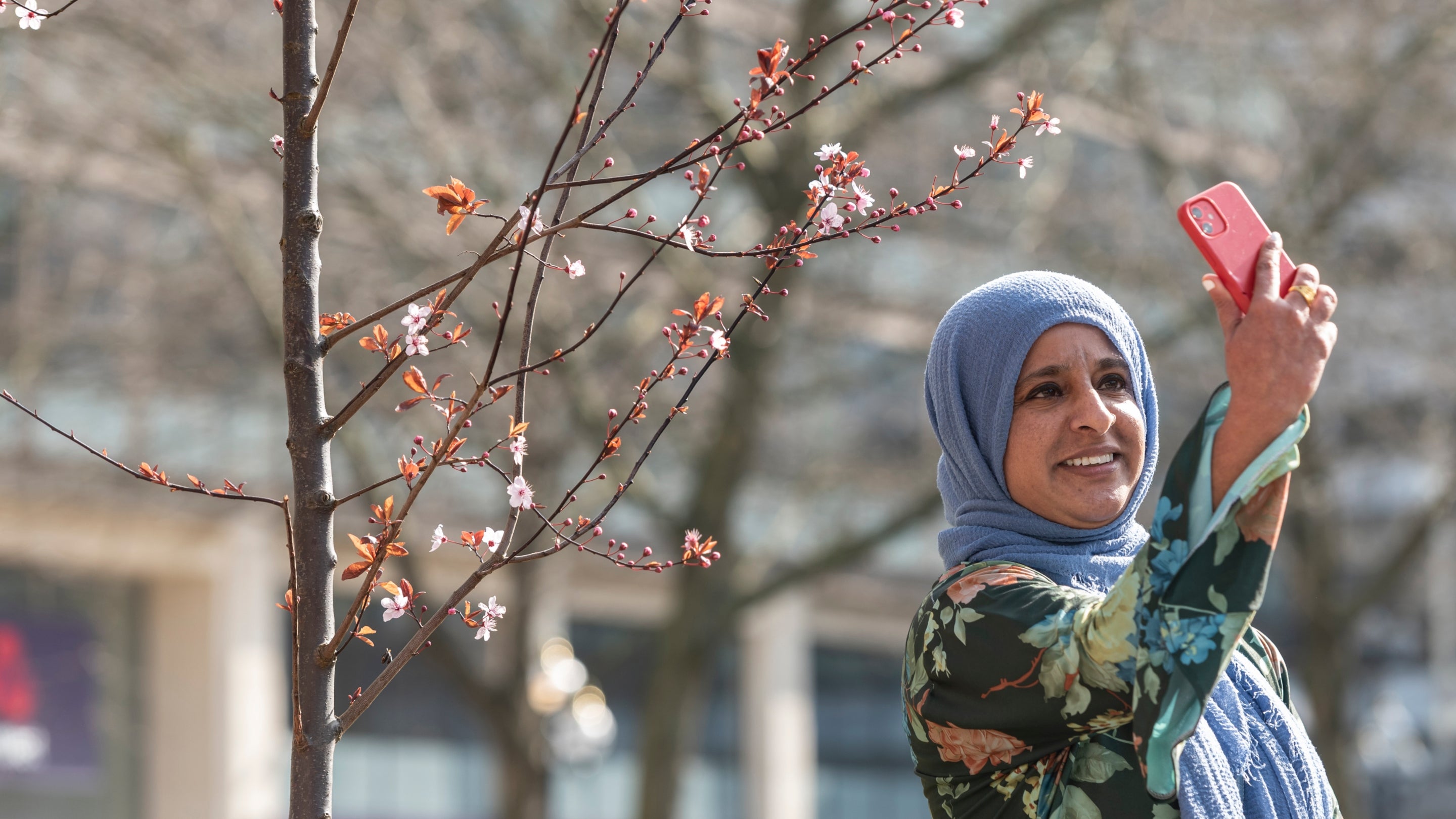 Taking a selfie in front of the pop-up blossom garden in St Phillip's Cathedral Square, Birmingham