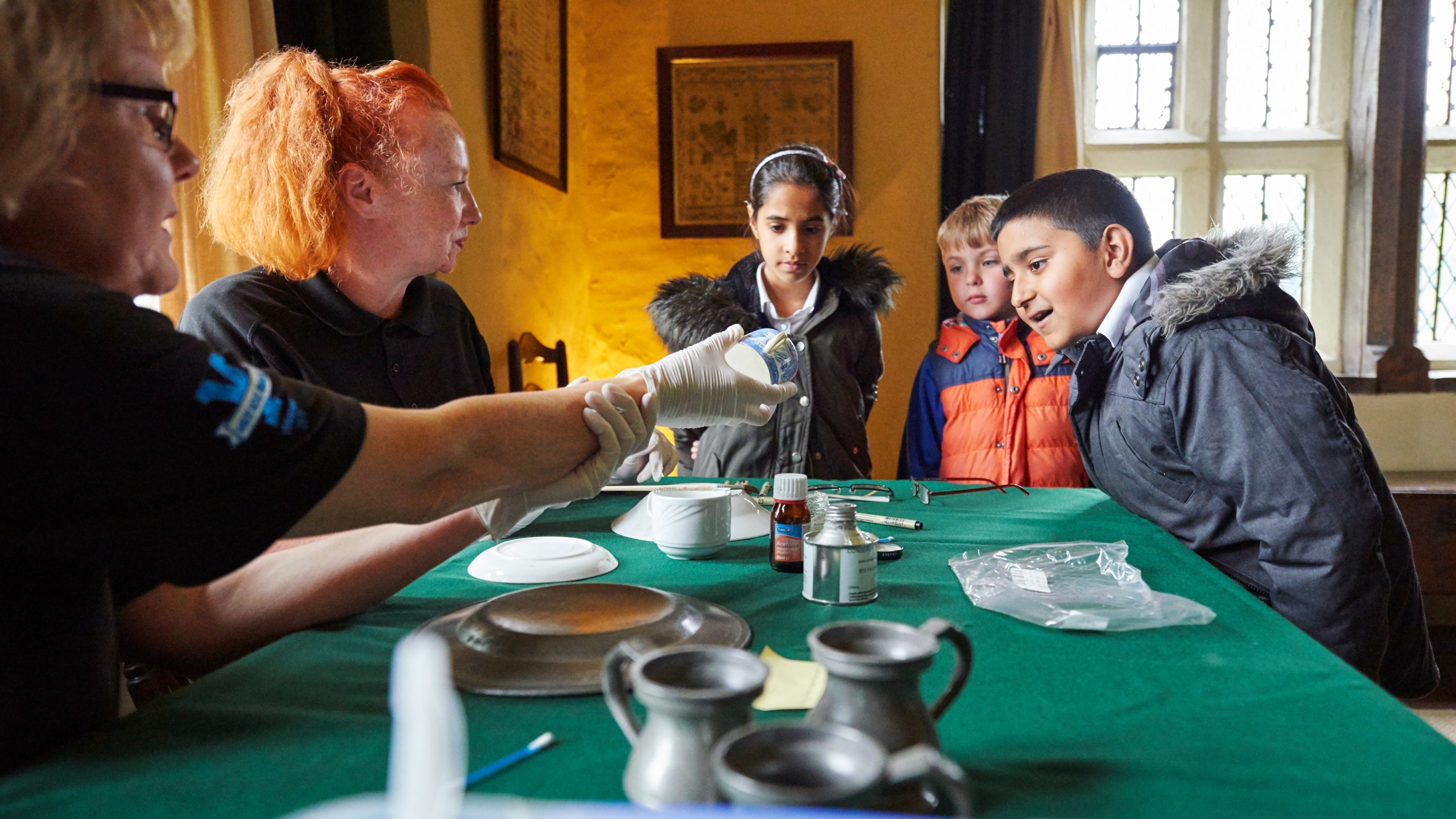 Children on a school trip to East Riddlesden Hall, West Yorkshire learn about conservation and care of collections