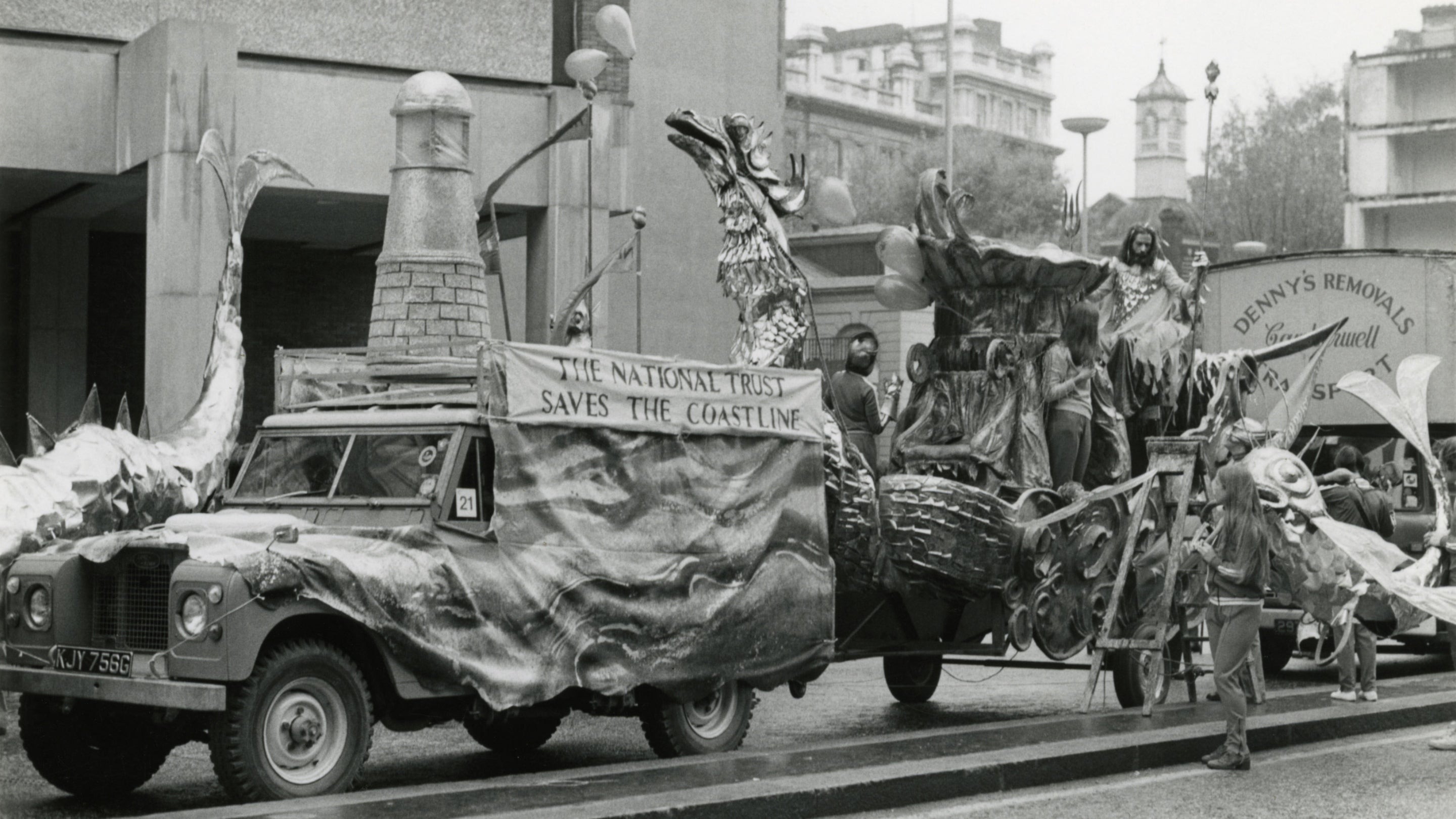 Black and white photo of a Land Rover pulling an underwater themed float in the Lord Mayor's Parade