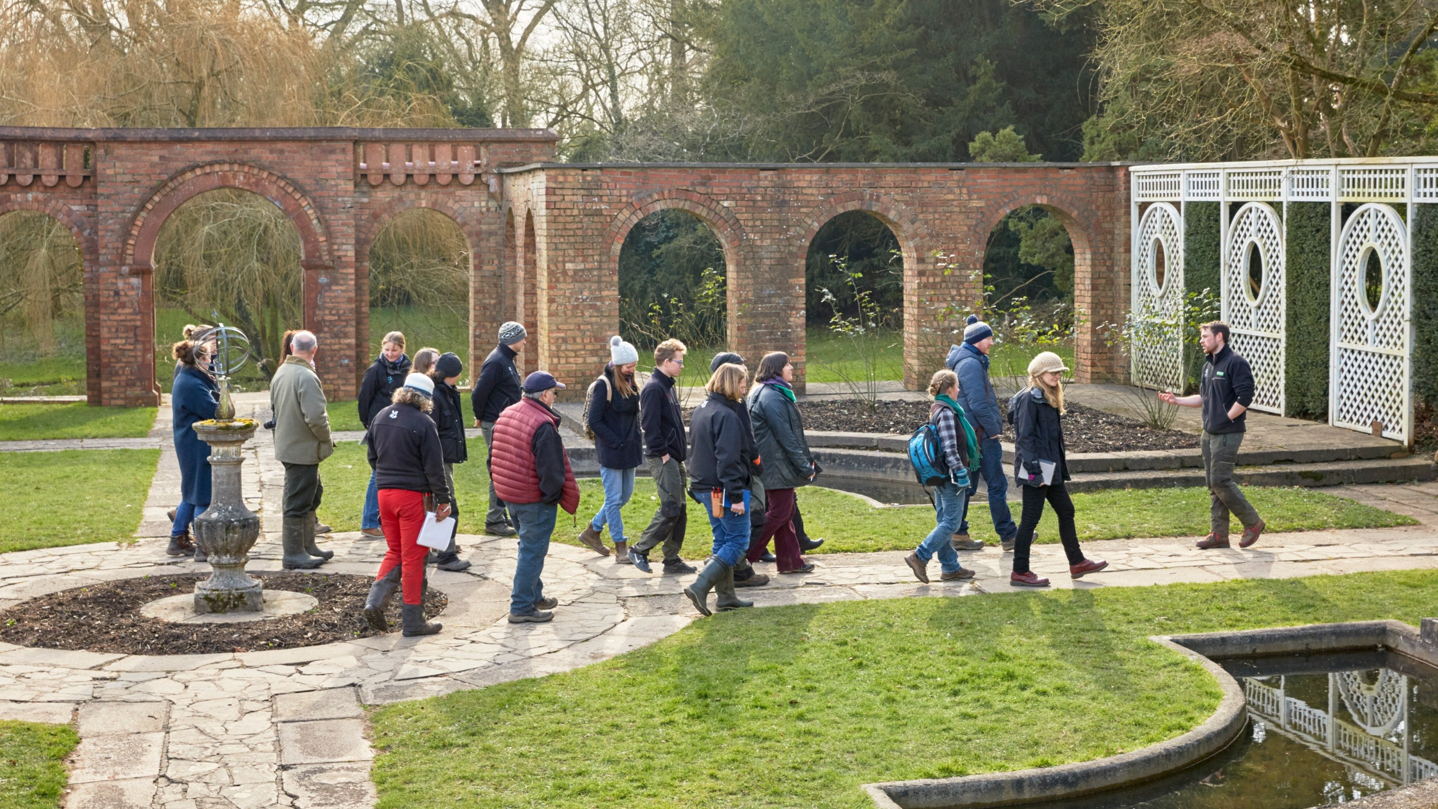 Visitors on a garden tour in the Pompeian Garden at Dyffryn House and Gardens, Vale of Glamorgan