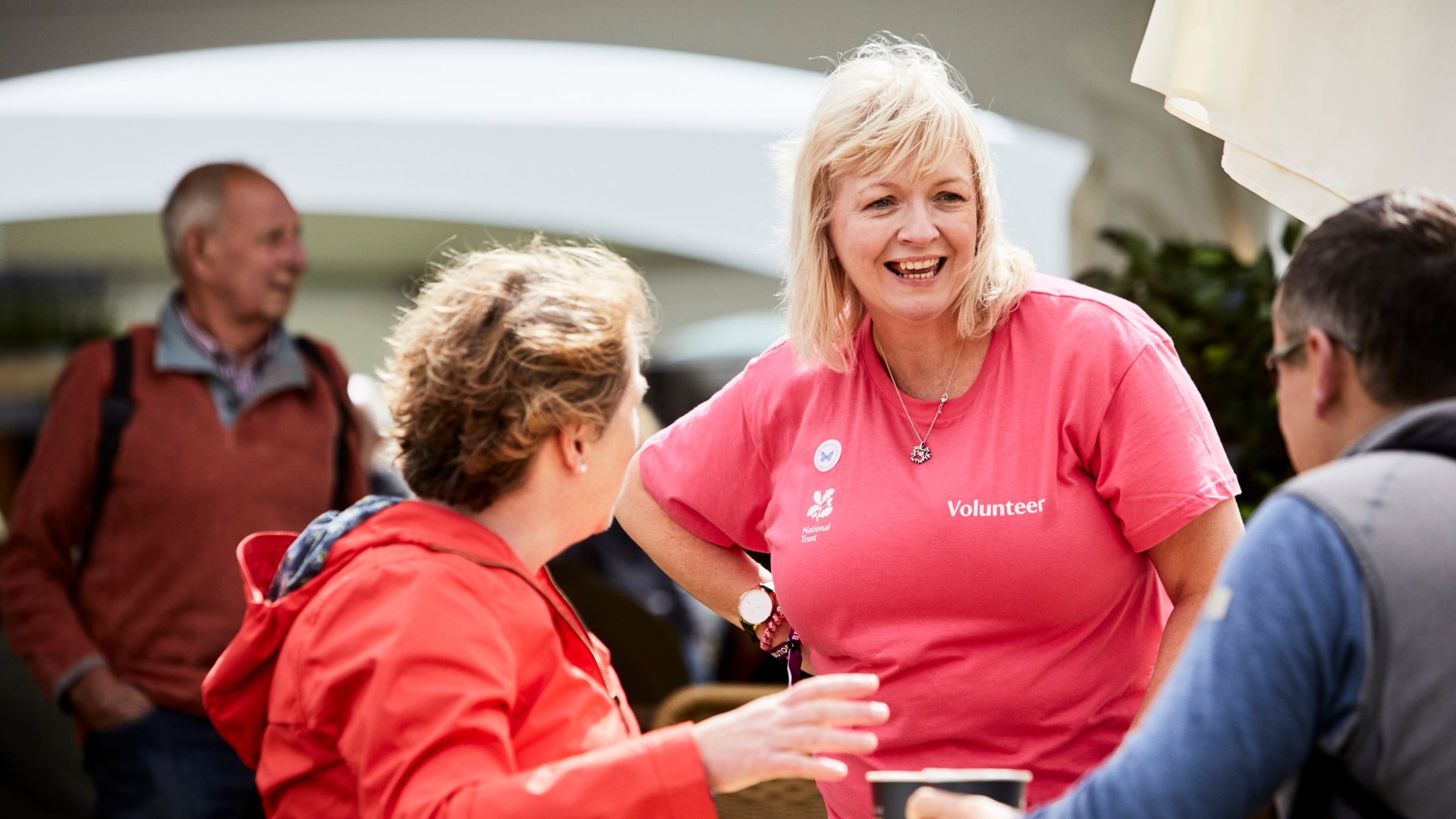 A close-up of three people from the National Trust standing around a table at Countryfile Live hosted at Blenheim Palace in 2017