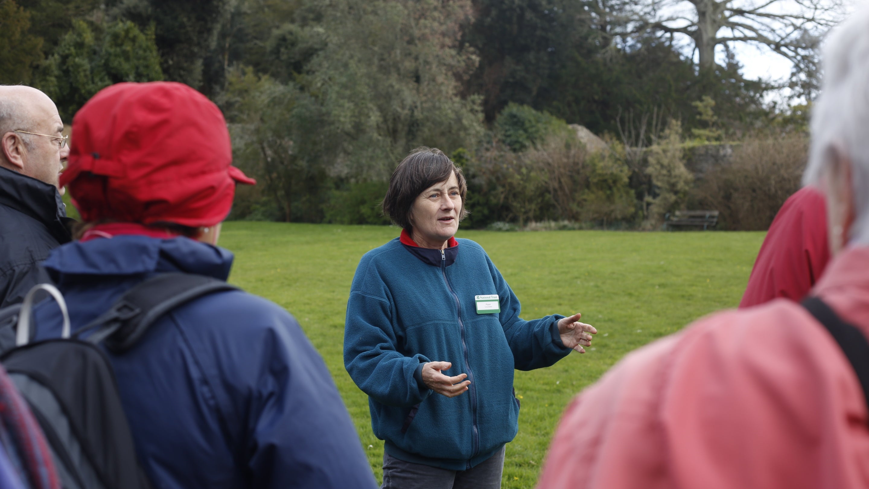 A staff member giving a talk to visitors in the garden at Greenway Devon