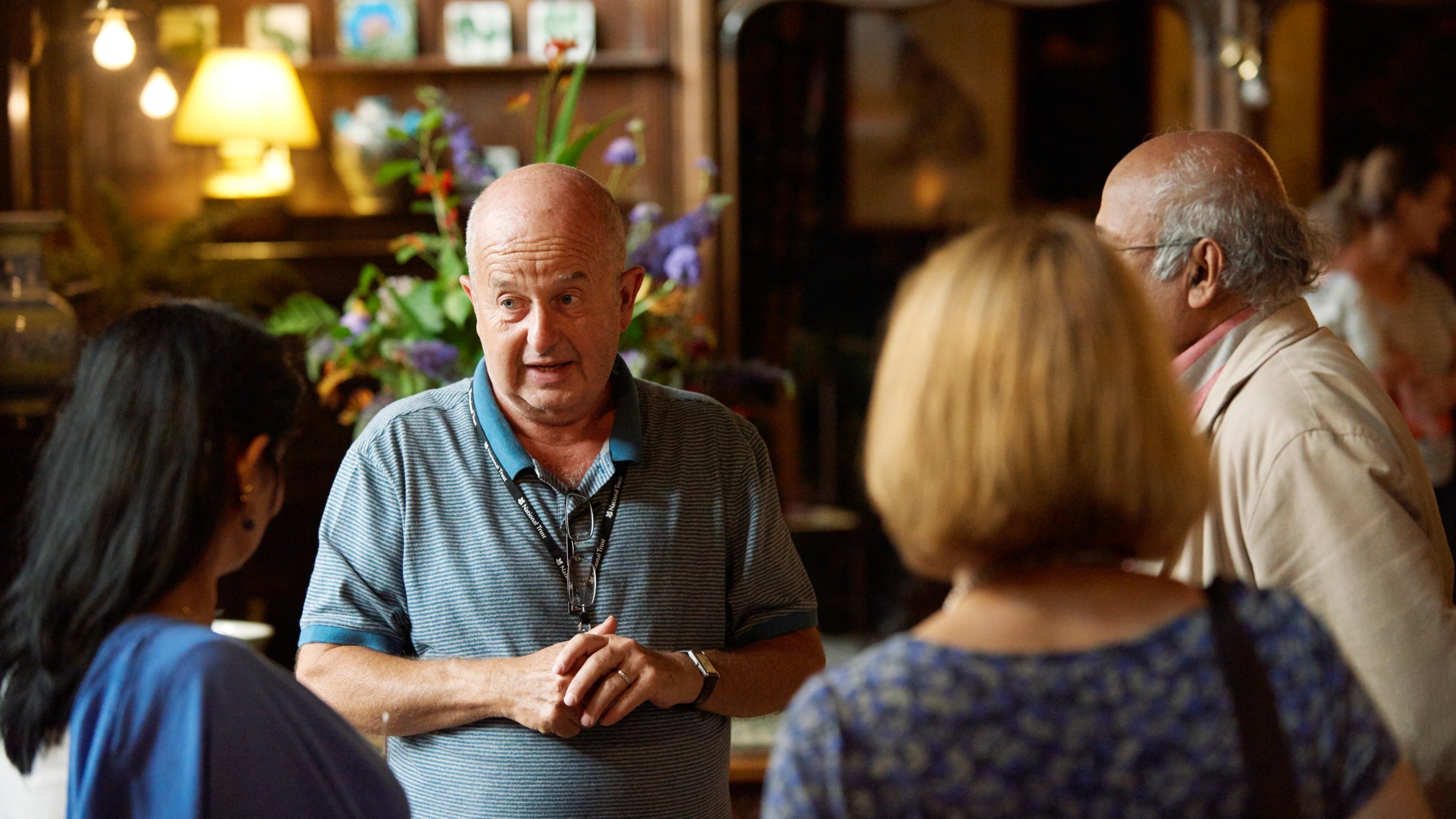 A volunteer talks to visitors at Wightwick Manor, West Midlands
