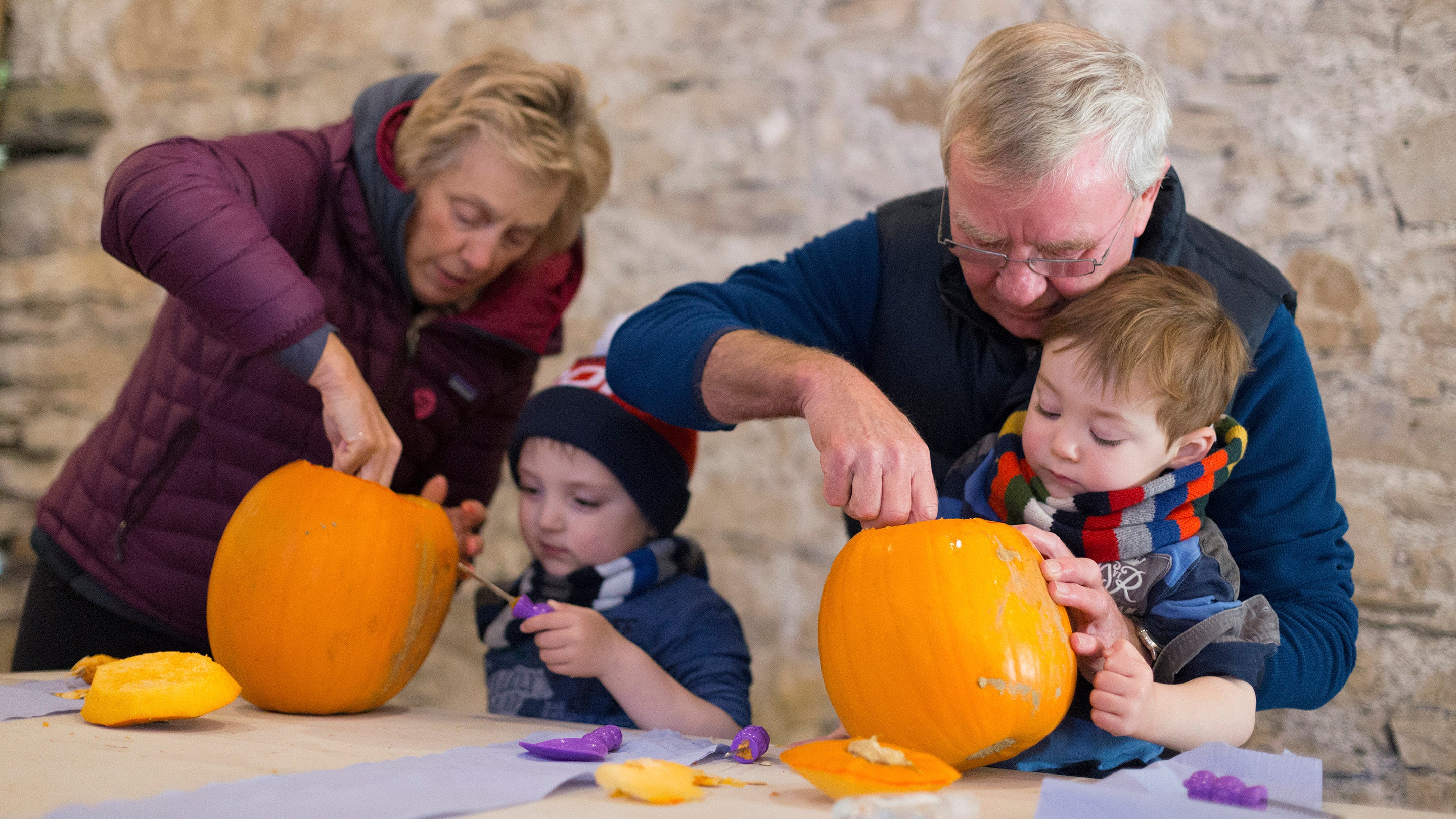 Children and adults carve pumpkins at Sizergh, Cumbria
