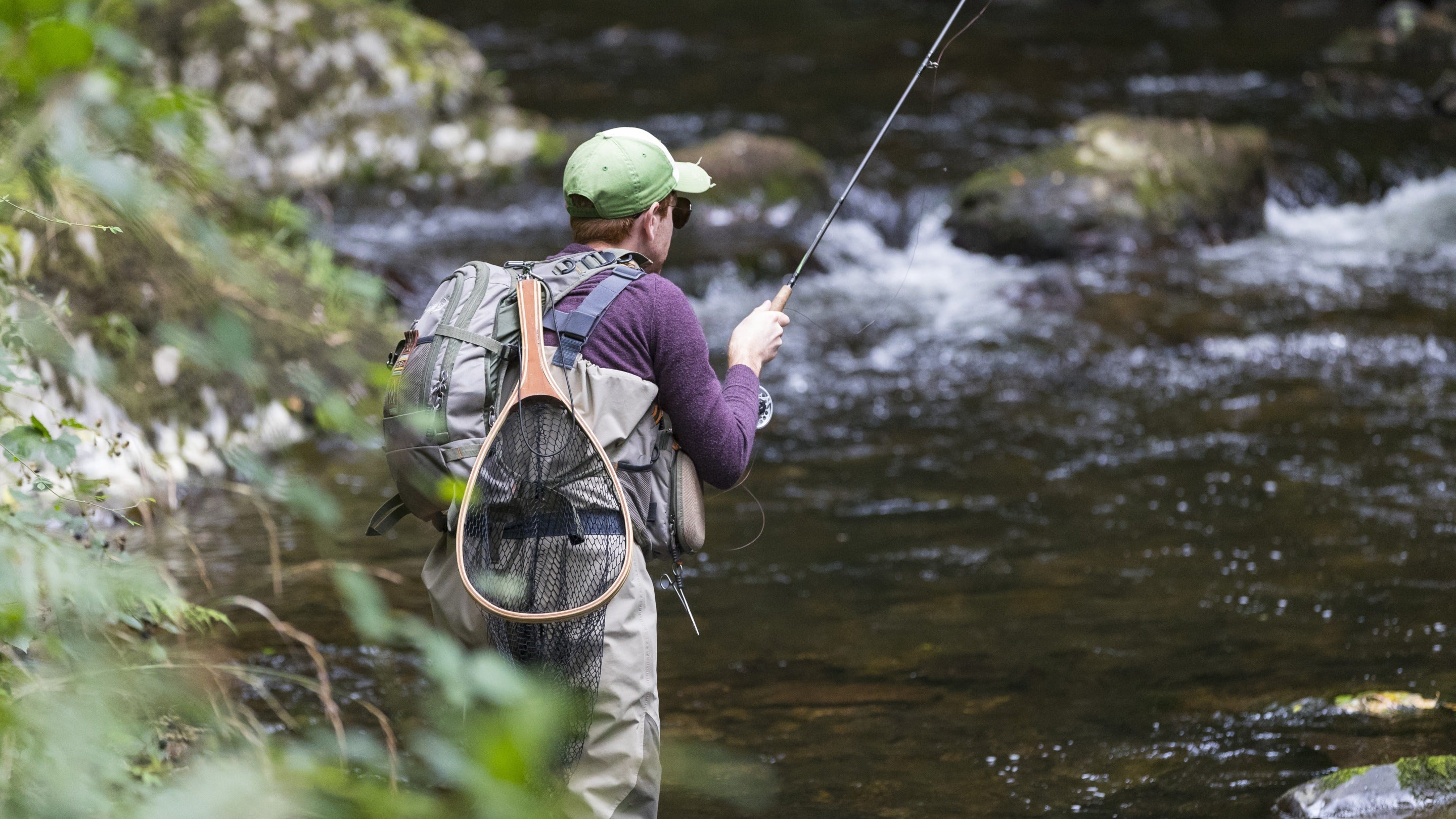 A fisherman fly fishing in the East Lyn river at Watersmeet, Devon