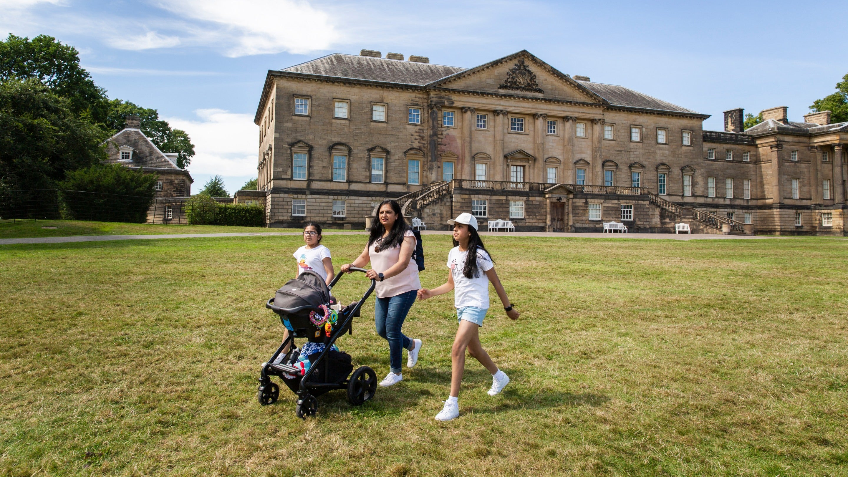 Visitors walking on the lawn in front of the mansion at Nostell, Yorkshire