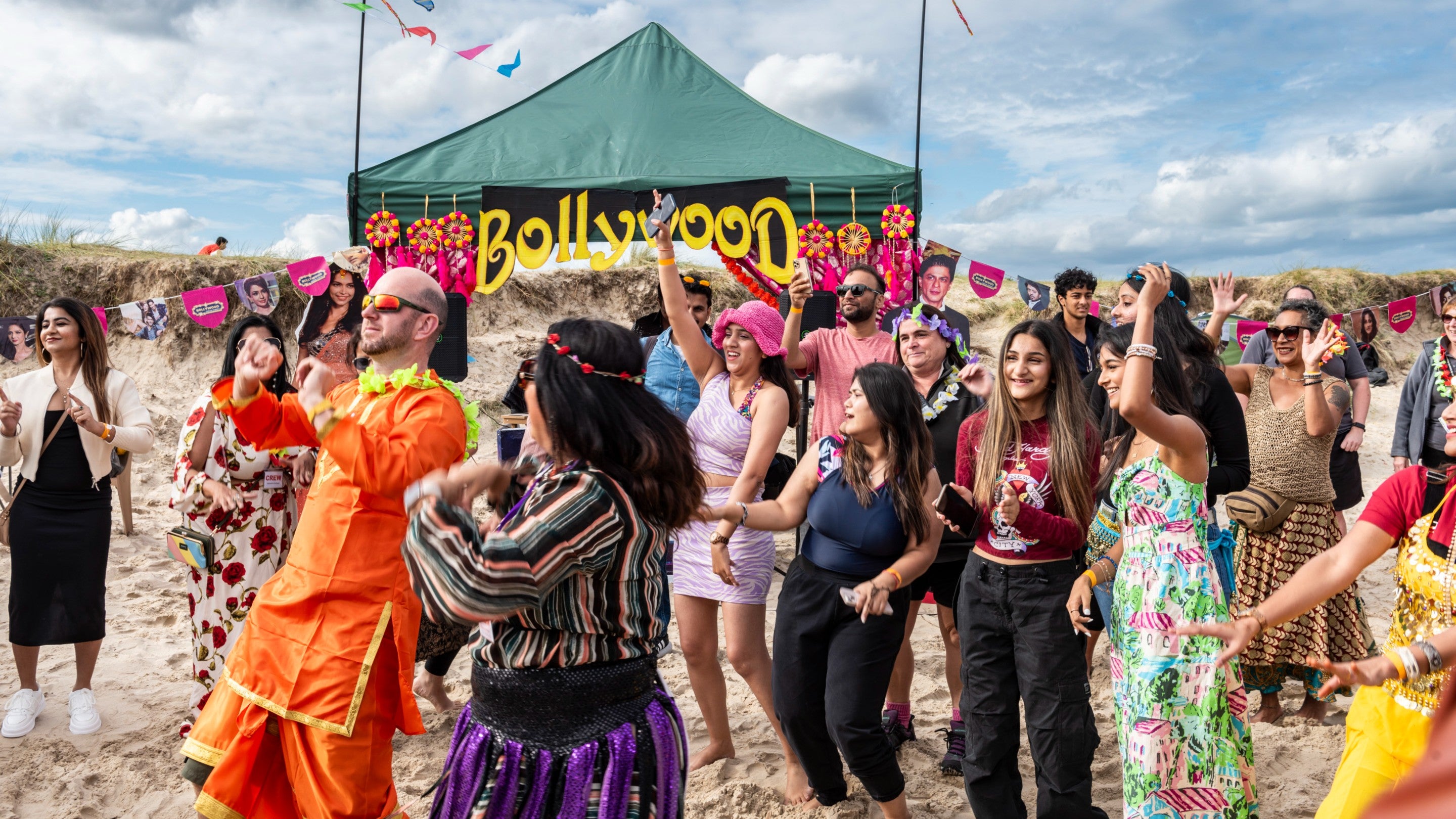 Visitors dancing at the Bollywood on the beach community event at Studland Bay, Dorset