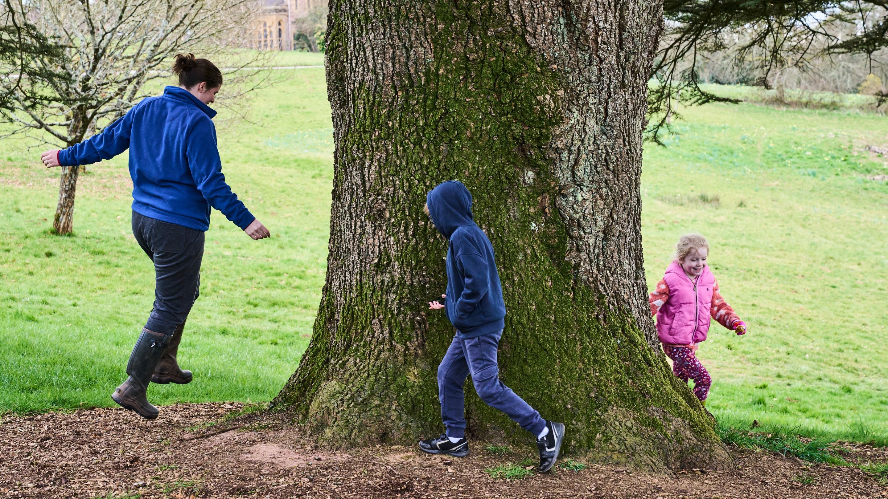 Visitors using the Stranger Folk app try wassailing near a tree at Knightshayes, Devon
